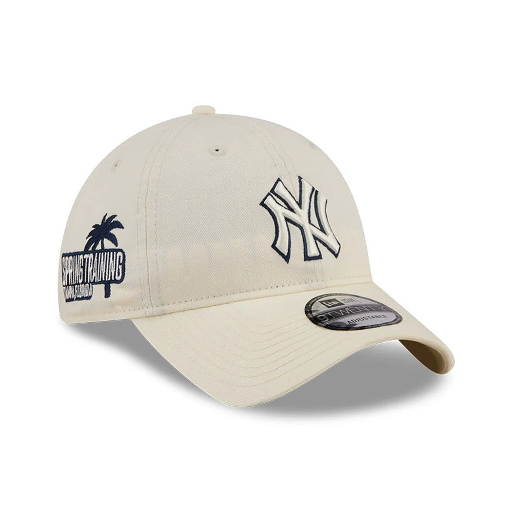 Yankees MLB Colours White New Era 9TWENTY Adjustable Cap, three-quarter view showing the navy embroidered NY logo on the front panel, curved white visor with a 9TWENTY size sticker, and a Spring Training logo on the left side.