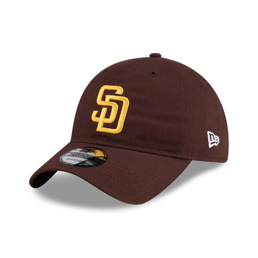 San Diego Padres MLB Colours Dark Brown New Era 9TWENTY Adjustable Cap, three-quarter view showing the raised yellow SD logo embroidered on the front panel, dark brown curved visor with a 9TWENTY size sticker, and New Era flag logo on the left side.
