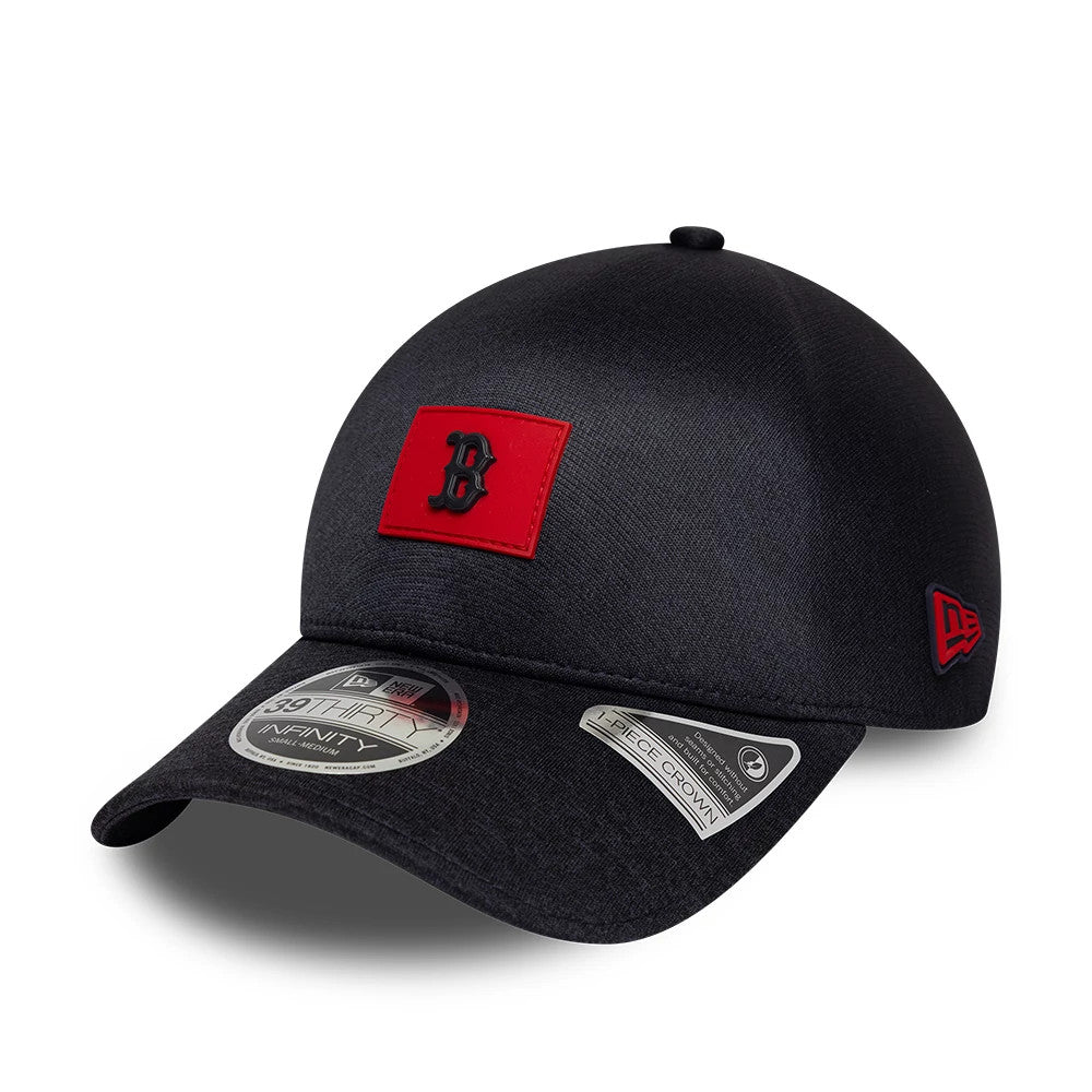 Boston Red Sox MLB Clubhouse Navy New Era 39THIRTY Infinity Stretch Fit Cap, three-quarter view showing the red and black embroidered B logo on the front panel, curved navy visor with 39THIRTY size sticker, and red New Era flag logo on the left side.
