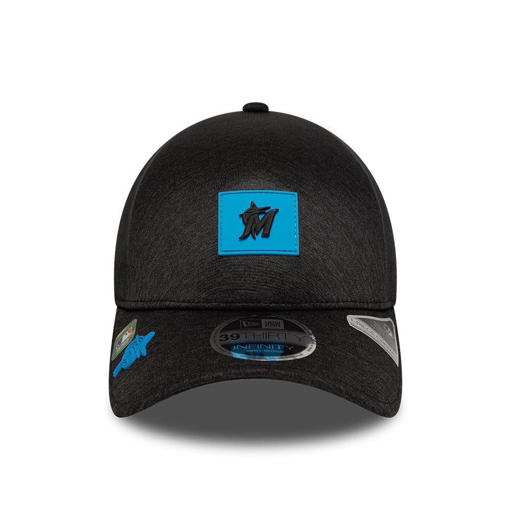 Miami Marlins MLB Clubhouse Black New Era 39THIRTY Infinity Stretch Fit Cap, front view showing a raised black embroidered Marlins logo on a blue patch, with a curved black visor featuring a 39THIRTY size sticker and team badge on the side.