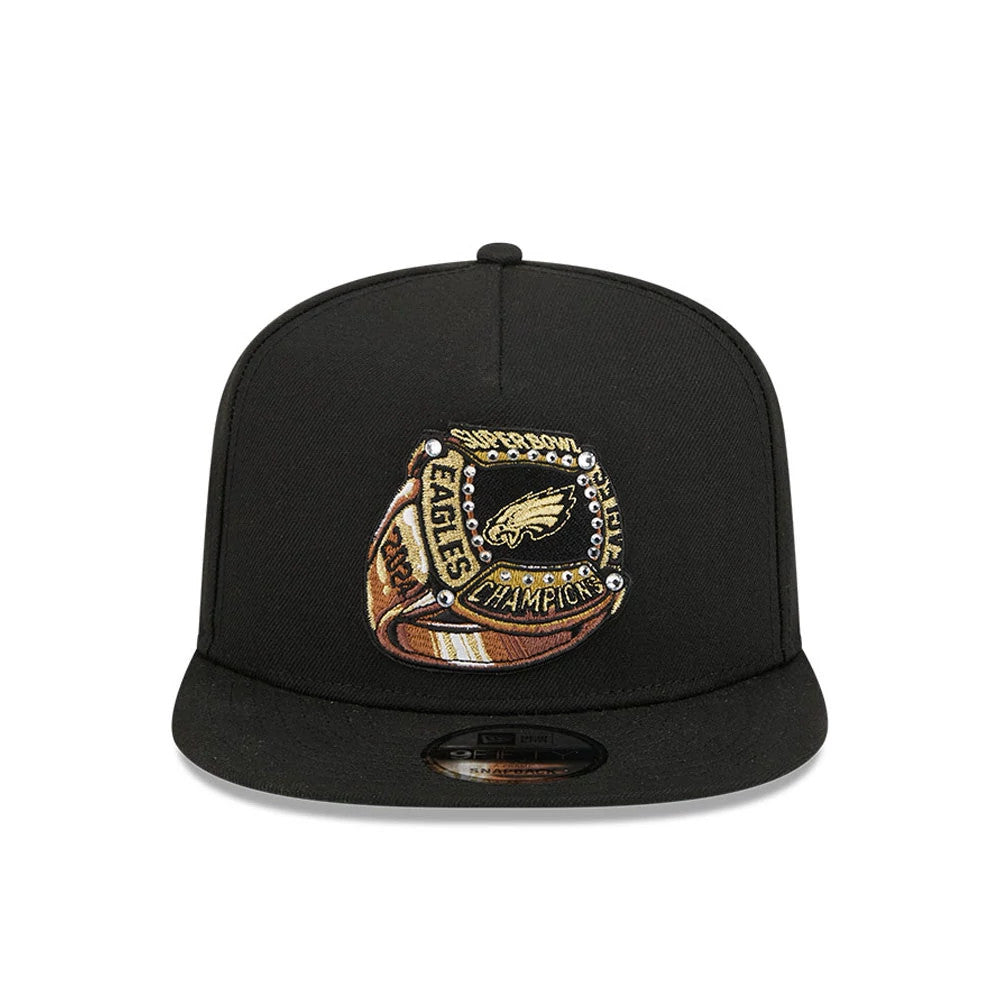 Philadelphia Eagles NFL Ring Black New Era 9FIFTY A-Frame Snapback Adjustable Cap, front view with a detailed embroidered Super Bowl Champions ring design on the structured black crown and a 9FIFTY size sticker on the flat visor.