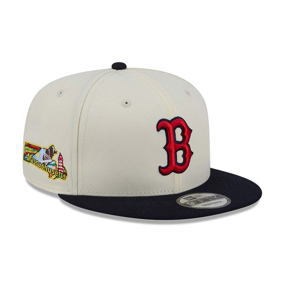 Boston Red Sox MLB Localized White New Era 9FIFTY Snapback Adjustable Cap, three-quarter view showing the raised red B embroidery on the front panel, Massachusetts graphic on the side, and black flat visor with a 9FIFTY size sticker.