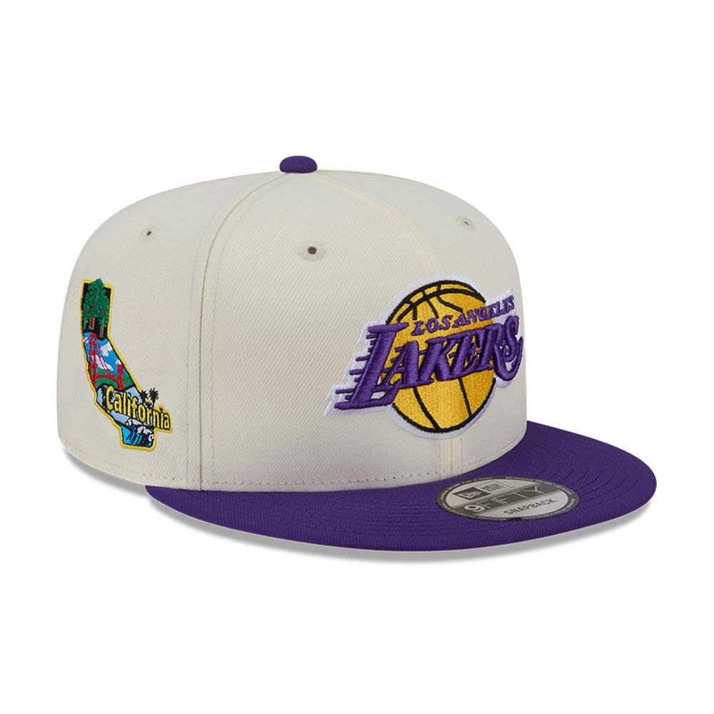 LA Lakers NBA Localized White New Era 9FIFTY Snapback Adjustable Cap, three-quarter view with a purple visor and size sticker, featuring a purple and gold Lakers logo on the front panel and a colourful California map patch on the side.