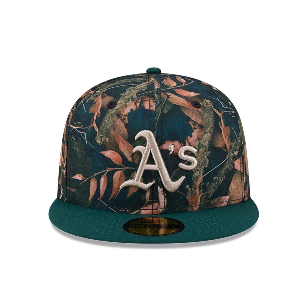 Athletics MLB Leaves Dark Green New Era 59FIFTY Fitted Cap, front view showing the silver embroidered A's logo on a leafy patterned front panel, with a dark green flat visor and a gold 59FIFTY size sticker on the visor.