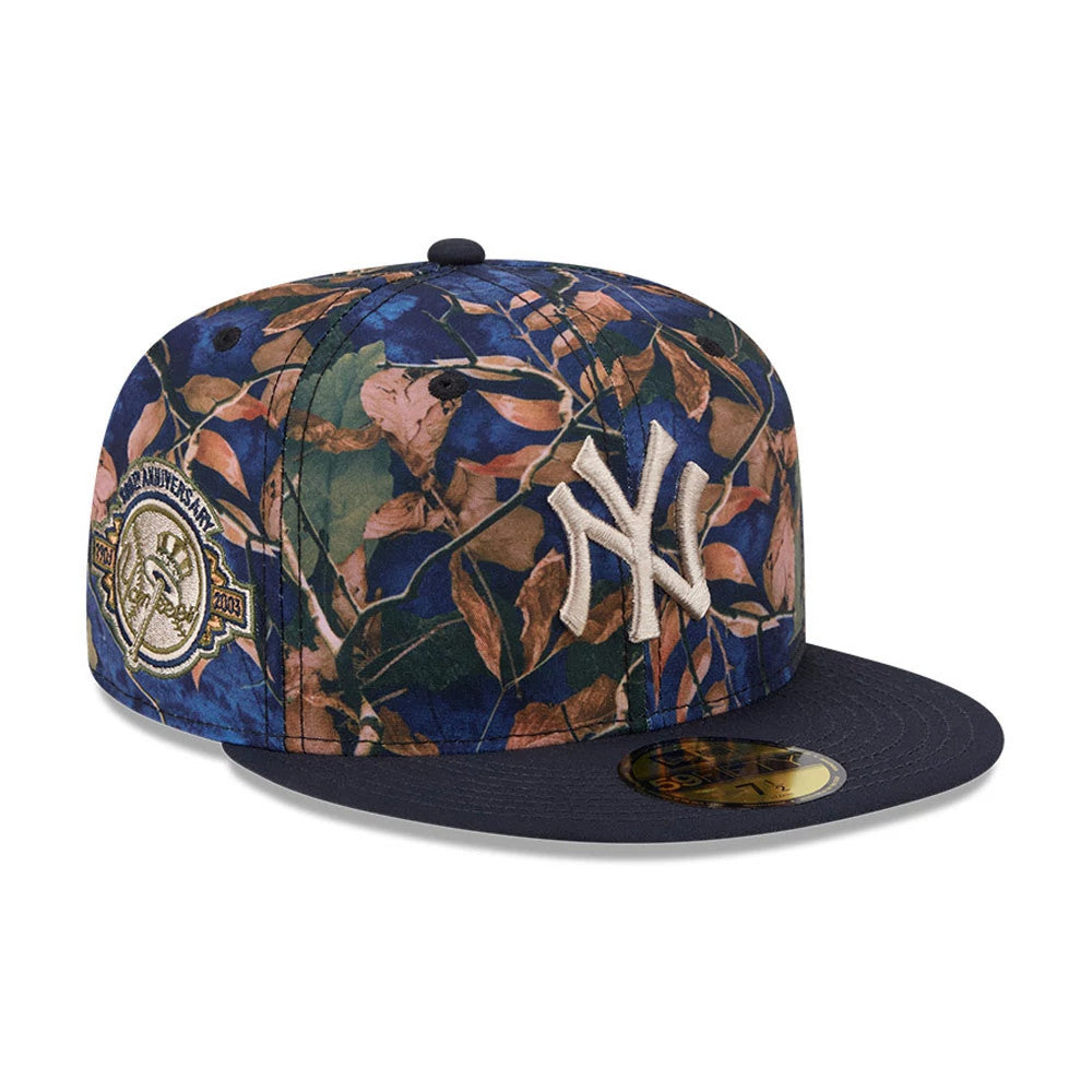 New York Yankees MLB Leaves Navy New Era 59FIFTY Fitted Cap, three-quarter view showing raised NY logo in white embroidery on a leaf-patterned crown, navy flat visor with gold 59FIFTY size sticker, and a commemorative patch on the side.