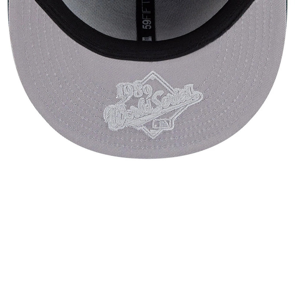 Athletics MLB Hidden Hit Dark Green New Era 59FIFTY Fitted Cap, inside view showing the grey undervisor with white embroidered 1989 World Series logo, black sweatband and black interior taping with 59FIFTY branding.