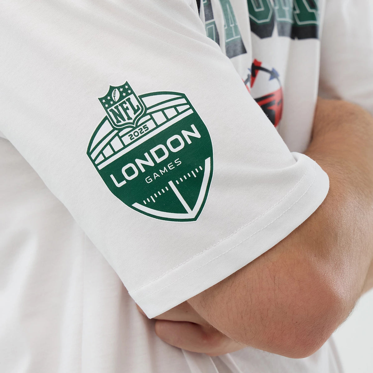New Era New York Jets NFL International Series Games White Oversized T-Shirt, side view showcasing a green printed London Games 2025 logo on the sleeve and view of graphic details on the chest.