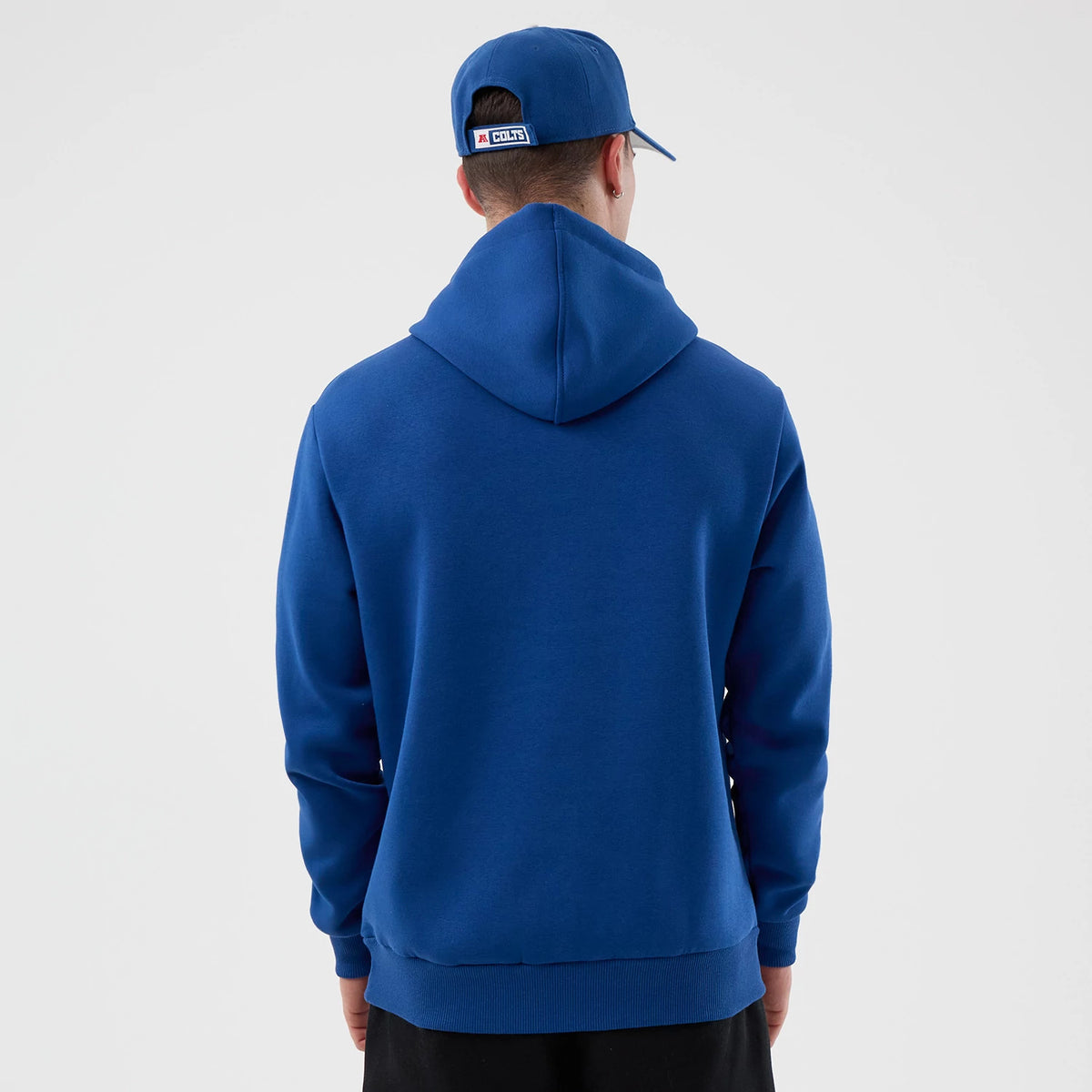 New Era Indianapolis Colts NFL International Series Games Blue Pullover Hoodie, back view displaying a plain blue design with a relaxed fit, worn on-model, featuring a drawstring hood and ribbed cuffs and hem for a classic sporty look.
