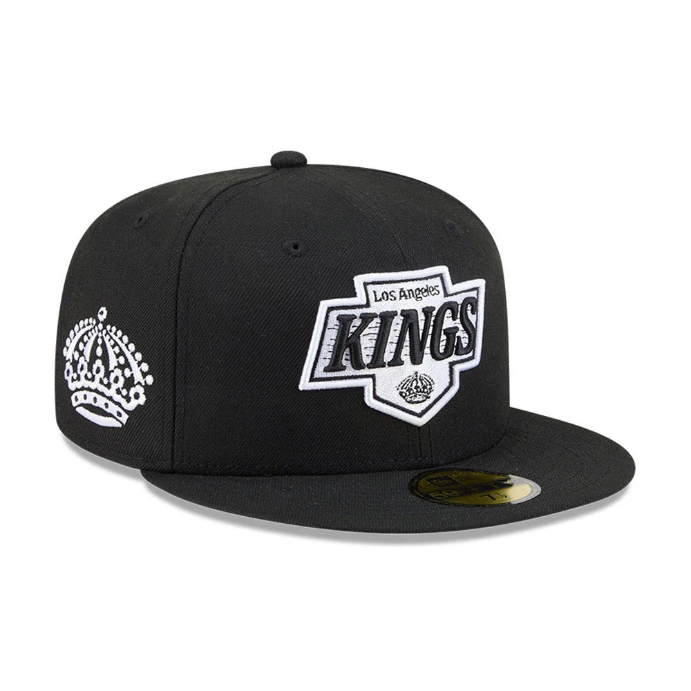LA Kings NHL Evergreen Black New Era 59FIFTY Fitted Cap, three-quarter view showing a black and white raised embroidered LA Kings logo on the front panel, a white crown logo on the left side, a flat black visor, and a gold 59FIFTY size sticker.