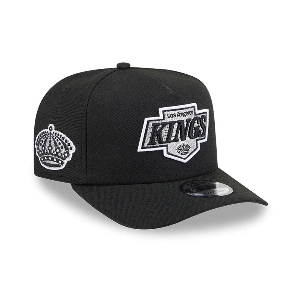 LA Kings NHL Evergreen Black New Era 9FIFTY A-Frame Snapback Adjustable Cap, three-quarter view showing the grey and black embroidered front logo, flat black visor with a 9FIFTY size sticker, and side crown logo on the left.