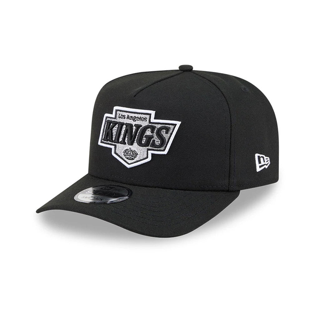 LA Kings NHL Evergreen Black New Era 9FIFTY A-Frame Snapback Adjustable Cap, front view showing the raised white and black embroidered Los Angeles Kings logo on the structured black crown, with a New Era flag logo on the left side.