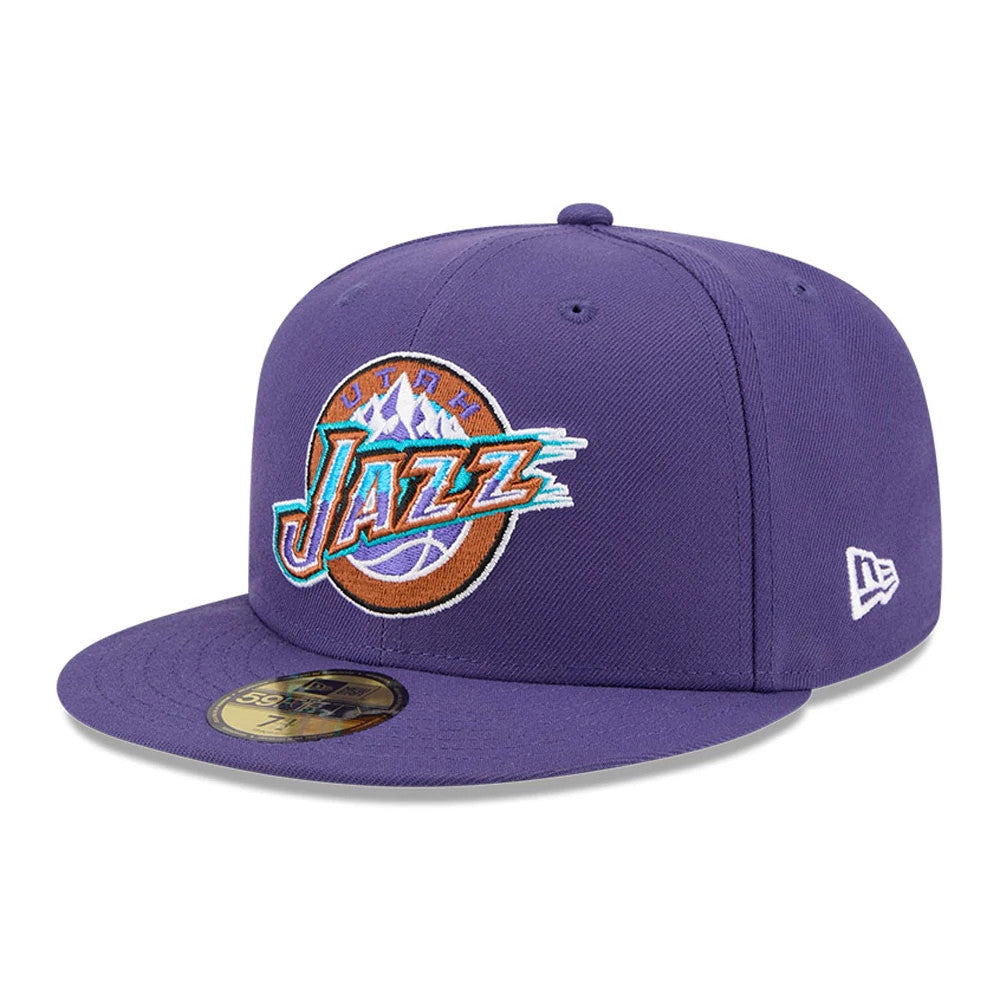 Utah Jazz NBA Hardwood Classic Dark Purple New Era 59FIFTY Fitted Cap, three-quarter view showing the embroidered Jazz logo on the front panels, flat dark purple visor with a gold 59FIFTY size sticker, and the New Era flag logo on the left side.