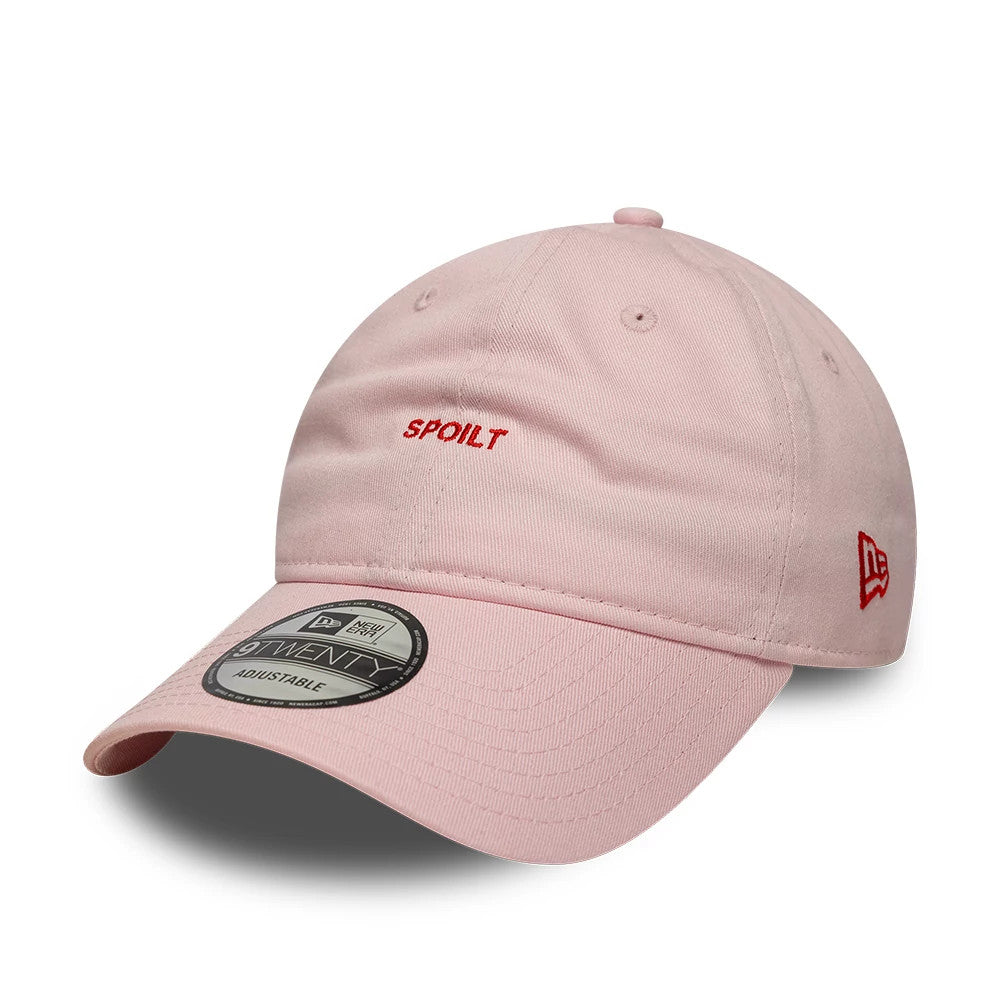New Era Slogan Spoilt Pastel Pink 9TWENTY Adjustable Cap, three-quarter view showing the red embroidered SPOILT text on the front panel and the New Era flag logo on the left side, with a black.