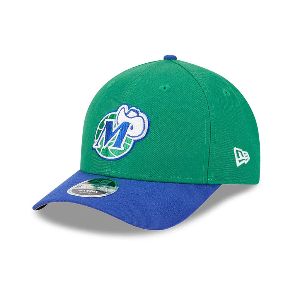 Dallas Mavericks NBA Classic Green New Era 9FORTY M-Crown Adjustable Cap, three-quarter view showing the white and blue embroidered Mavericks logo on the front panel, blue curved visor, and 9FORTY size sticker.