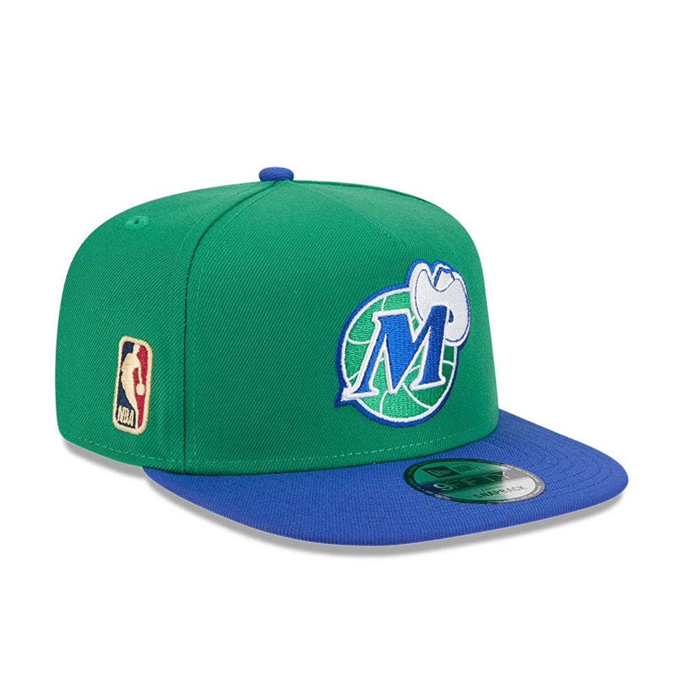 Dallas Mavericks NBA Classic Green New Era 9FIFTY A-Frame Snapback Adjustable Cap, three-quarter view showing the raised Dallas Mavericks logo on the front panel, blue flat visor with a 9FIFTY size sticker, and embroidered NBA logo on the left side.