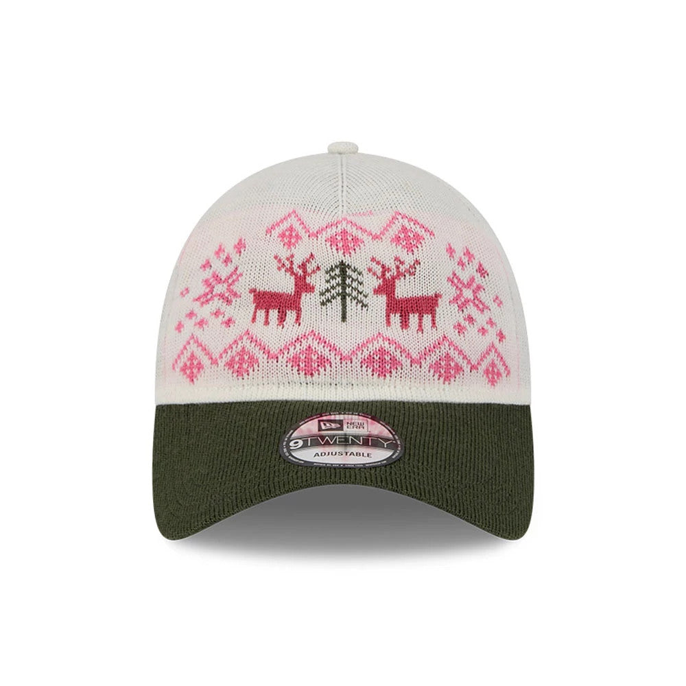New Era Holiday Essentials White 9TWENTY Adjustable Cap, front view featuring a pink and red festive pattern with reindeer and tree on the white crown, complemented by a dark green curved visor and a 9TWENTY size sticker.
