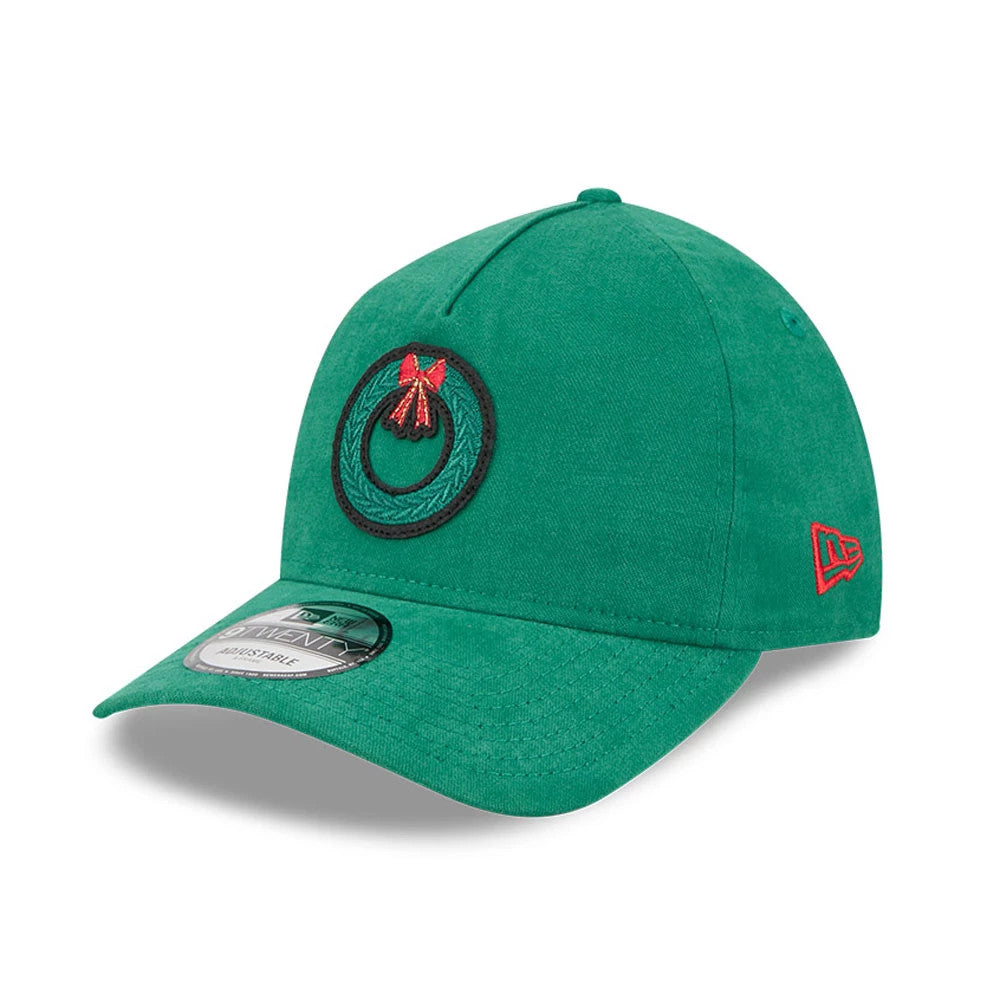 New Era Holiday Essentials Green New Era 9TWENTY A-Frame Adjustable Cap, three-quarter view showing a green embroidered wreath with a red bow on the front panel, a red New Era flag logo on the left side.