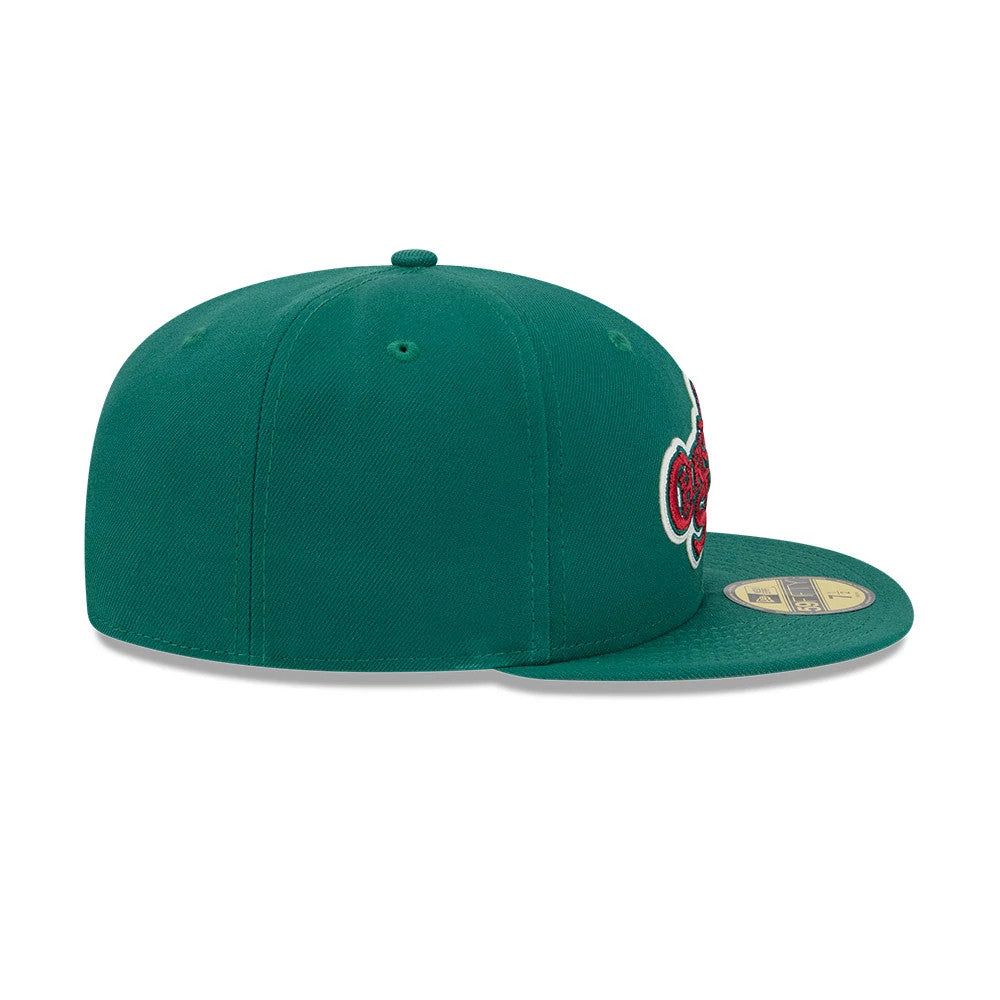 A Christmas Story Warner Brothers Green New Era 59FIFTY Fitted Cap, side view showing the structured green crown with red and white embroidered text on the front panel, and a gold 59FIFTY size sticker on the flat green visor.