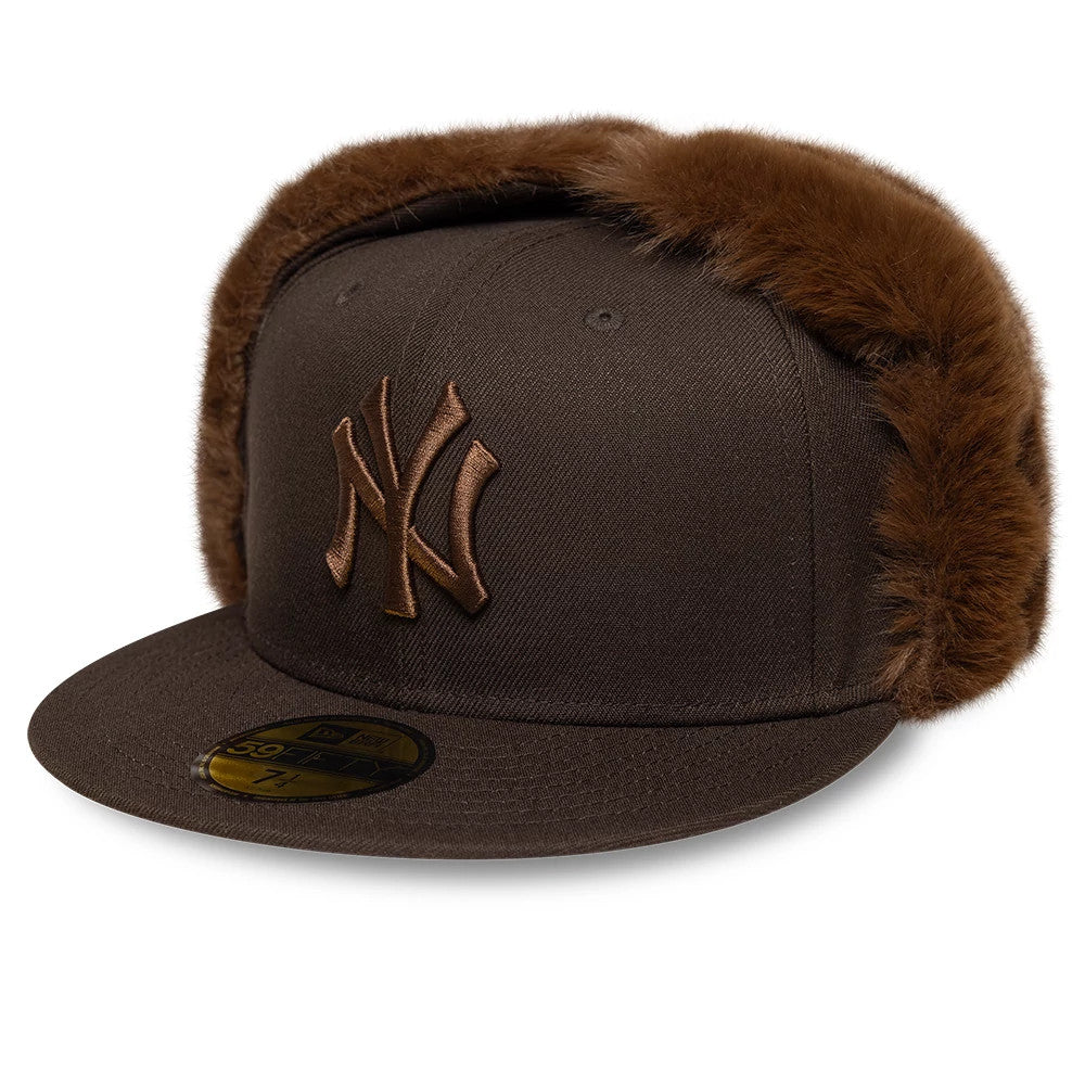 New York Yankees MLB World Series Dark Brown Dogear New Era 59FIFTY Fitted Cap, front view showing raised brown NY logo embroidery on the front panel, flat visor visor with a gold 59FIFTY size sticker, and dark brown faux fur dogears.