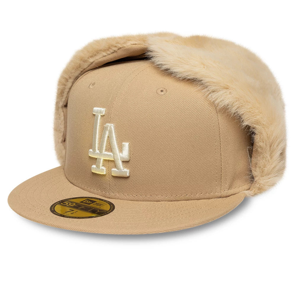 LA Dodgers MLB World Series Light Beige New Era Dogear 59FIFTY Fitted Cap, three-quarter view showing a raised white LA logo on the front panel, light beige fur-lined ear flaps, a flat visor, and a gold 59FIFTY size sticker.