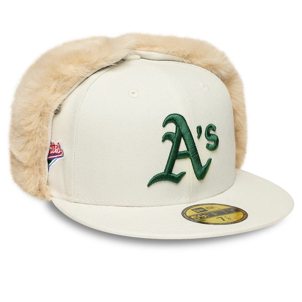 Athletics MLB World Series Cream Dogear New Era 59FIFTY Fitted Cap, three-quarter view showing the green embroidered A's logo on the front panel, cream dogears, and gold 59FIFTY size sticker on the flat cream visor.