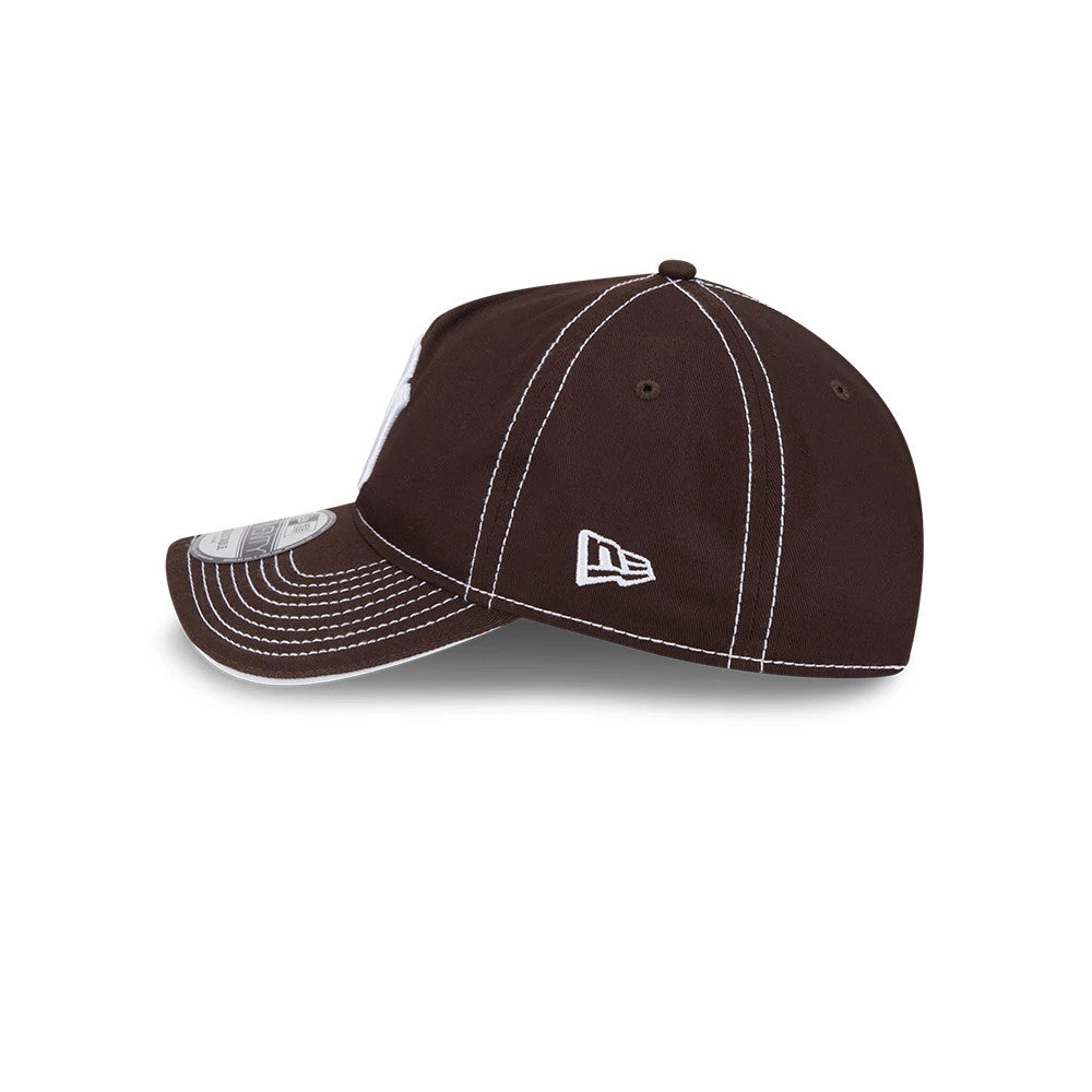 New York Yankees MLB Contrast Dark Brown New Era 9TWENTY A-Frame Adjustable Cap, side view showing the white New Era flag logo on the left side with white contrast stitching on the dark brown crown and visor, including a 9TWENTY size sticker.