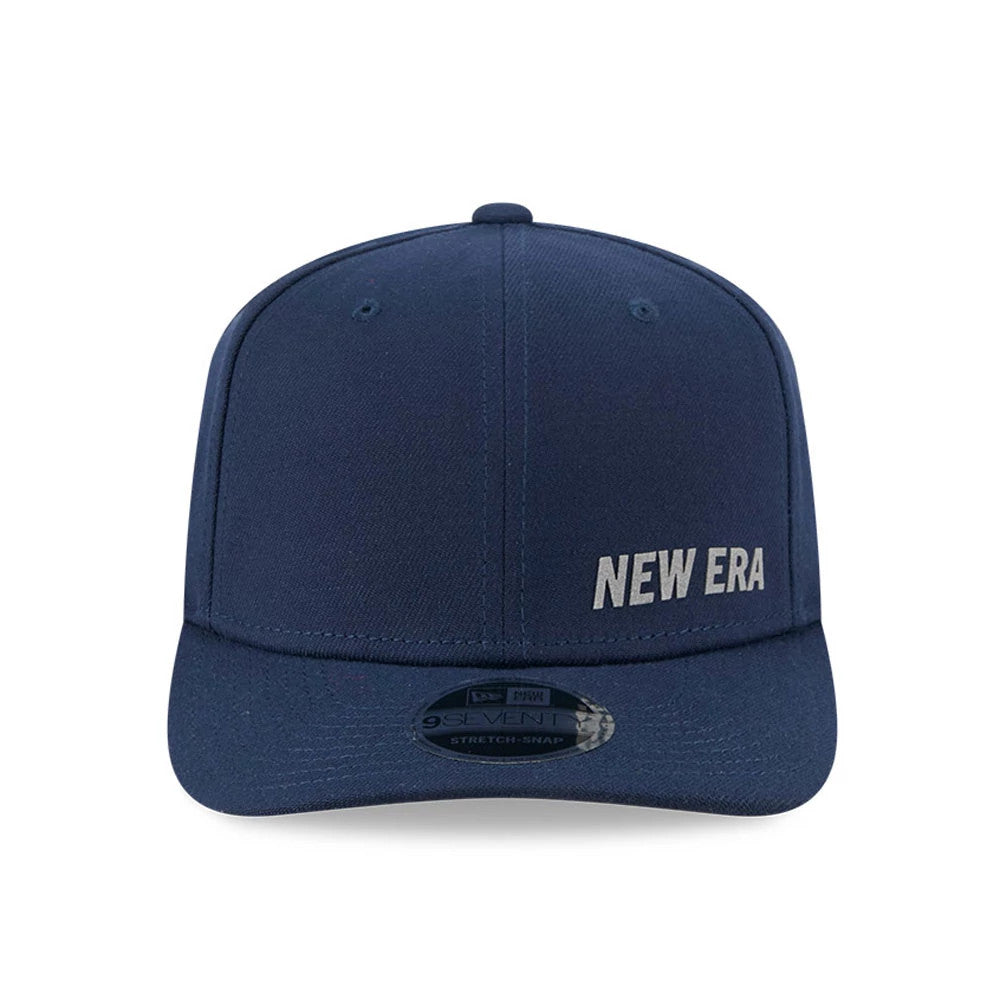 New Era Flawless Dark Blue 9SEVENTY Stretch Snap Adjustable Cap, front view with raised silver New Era embroidered logo on the right front panel, navy curved visor and 9SEVENTY size sticker.