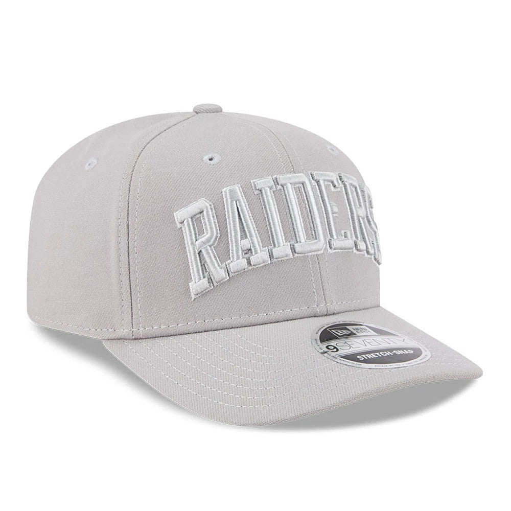 Las Vegas Raiders NFL Script Grey New Era 9SEVENTY Stretch Snap Adjustable Cap, three-quarter view showing the raised white Raiders script lettering on the front panel, grey curved visor and 9SEVENTY size sticker on top.