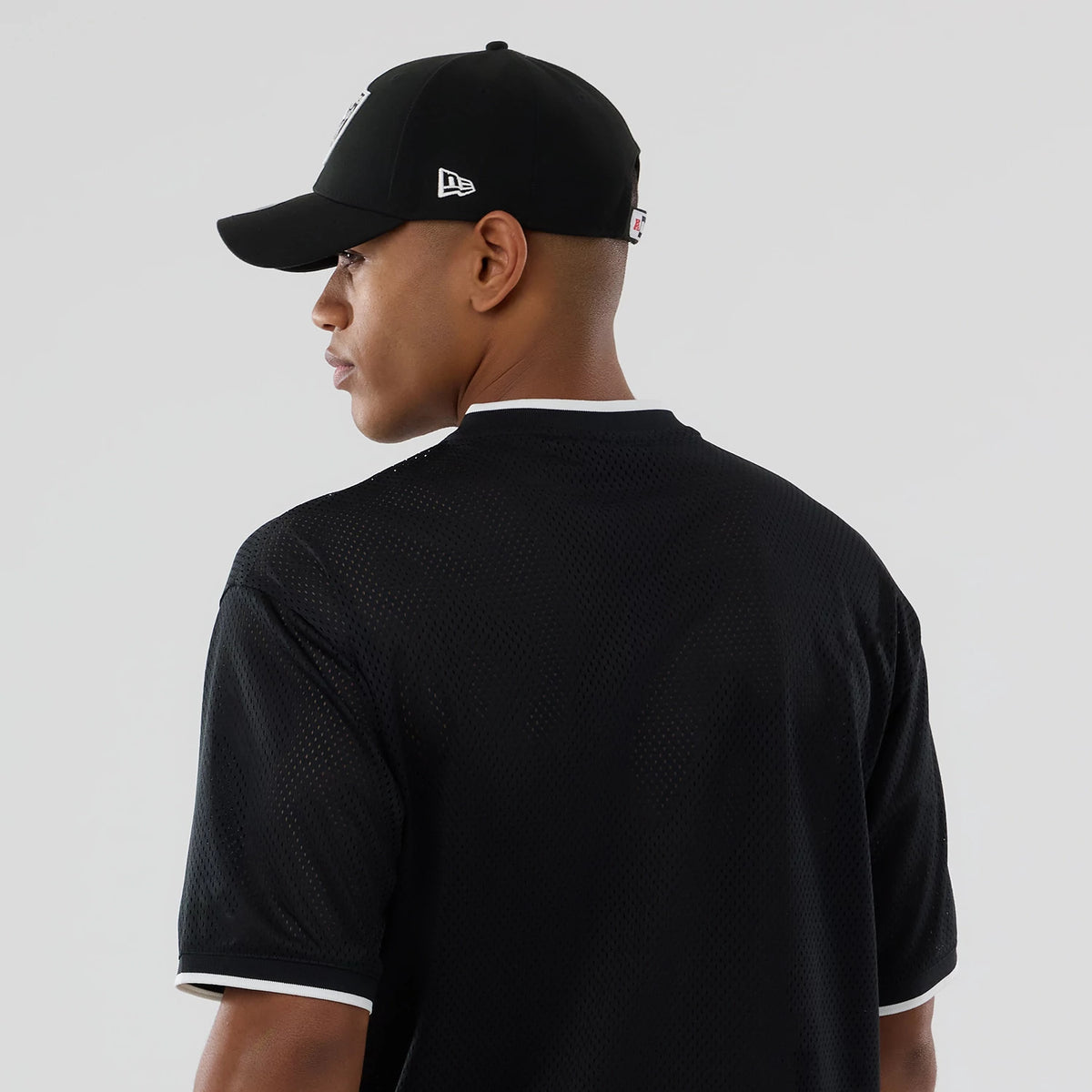 The model is wearing this NFL Mesh Las Vegas Raiders Oversized T-Shirt in black. 7
