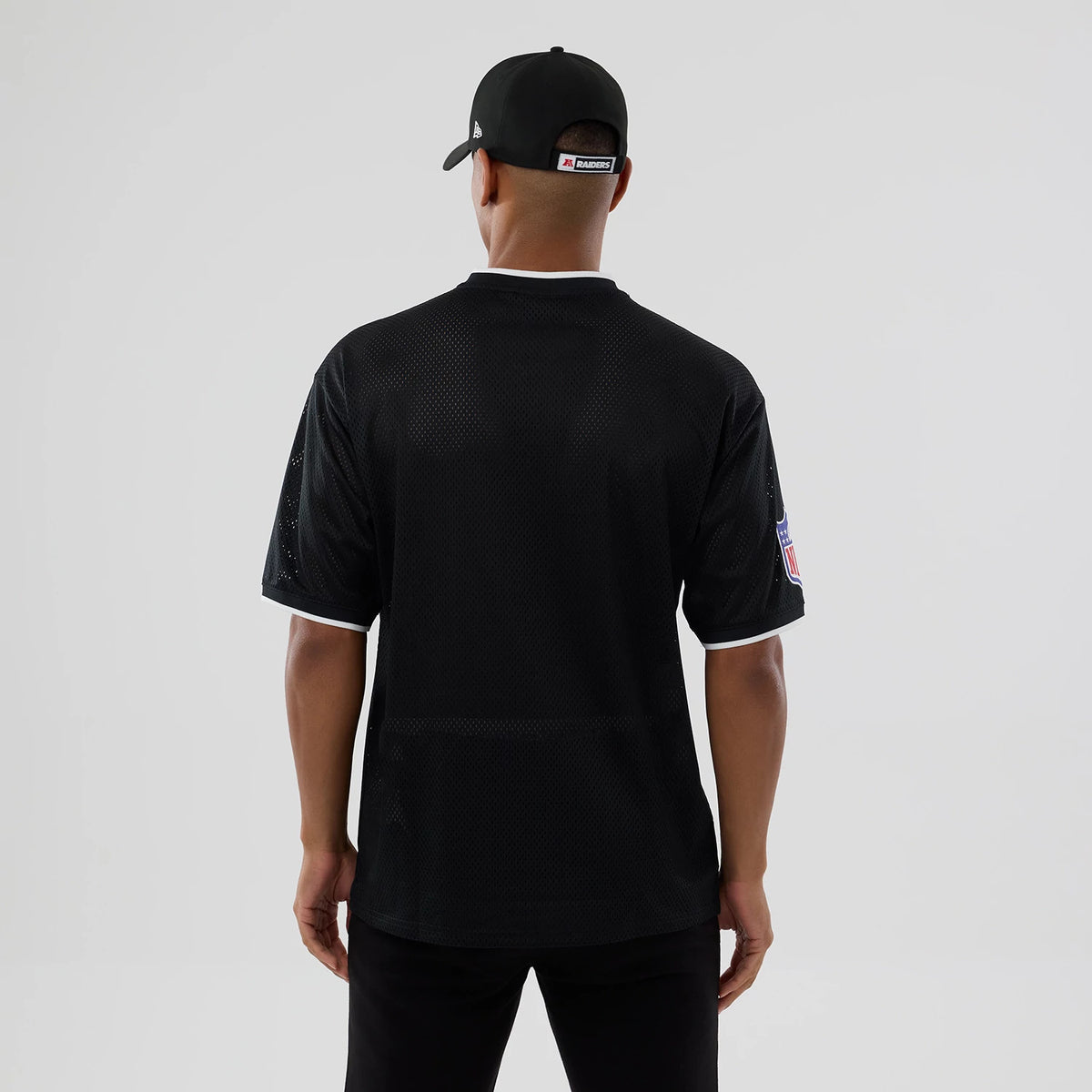 The model is wearing this NFL Mesh Las Vegas Raiders Oversized T-Shirt in black. 2
