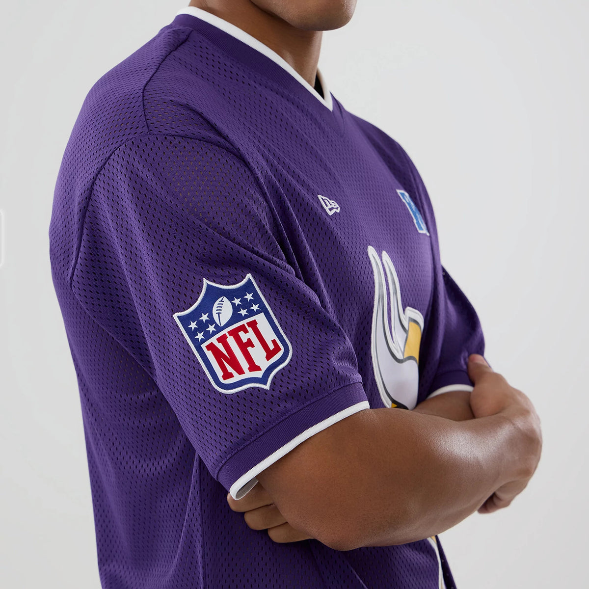 New Era Minnesota Vikings NFL Mesh Purple Oversized T-Shirt, three-quarter view showing the embroidered NFL shield on the right sleeve, the Vikings logo on the chest, and a raised New Era logo on the front shoulder.