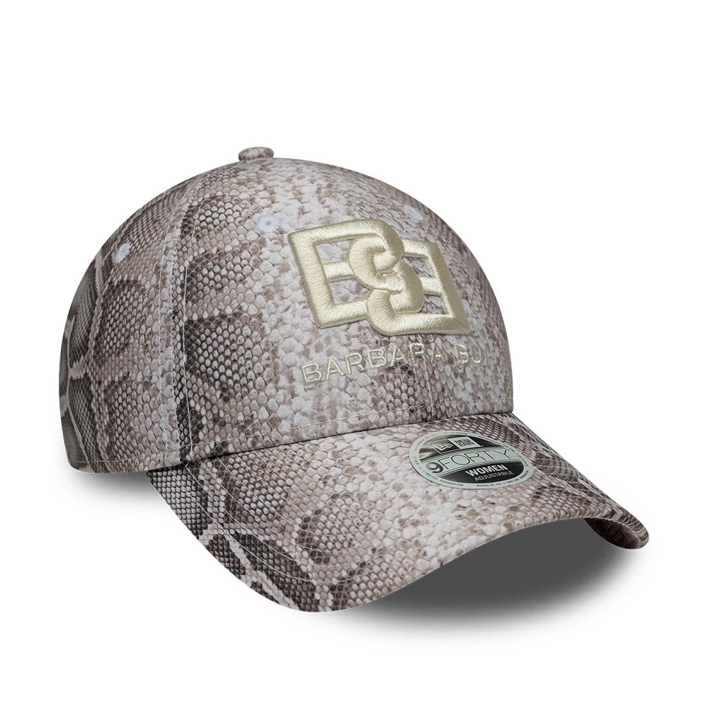 Womens New Era X Barbara Bui Python All Over Print 9FORTY Adjustable Cap, three-quarter view showing the gold embroidered logo on the front panel with a matching size sticker on the curved python print visor.