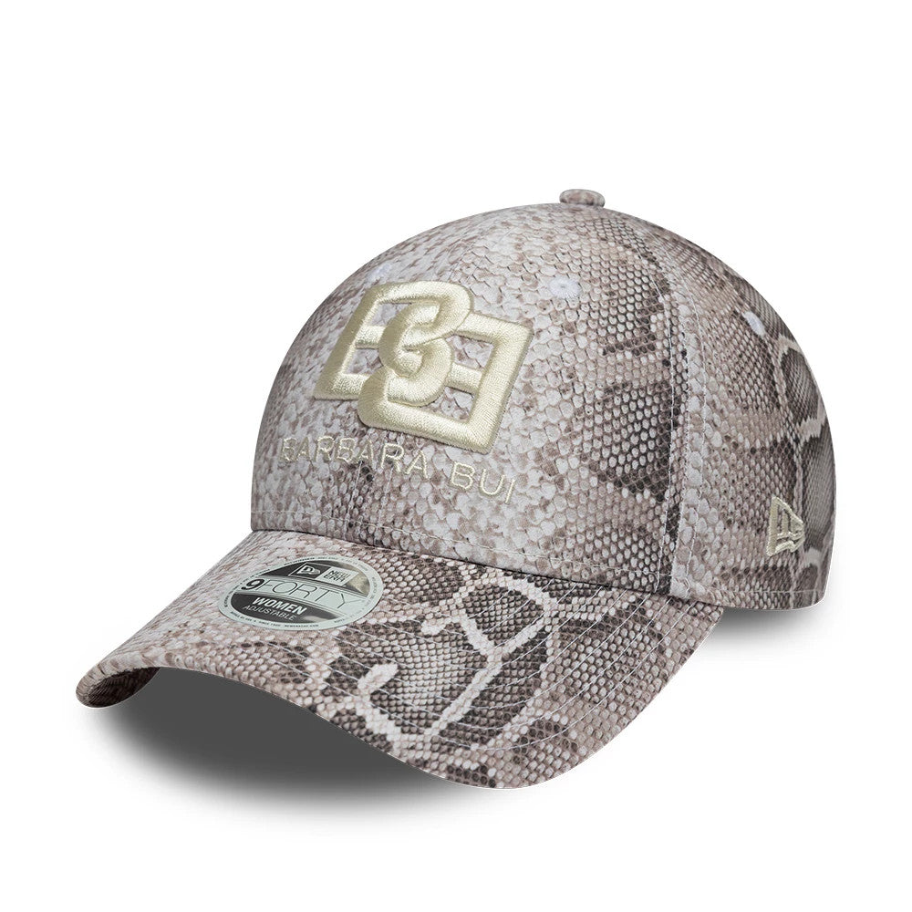 Womens New Era X Barbara Bui Python All Over Print 9FORTY Adjustable Cap, three-quarter view showing the gold embroidered Barbara Bui logo on the front panel, snake print covering the entire cap, and a 9FORTY size sticker on the curved visor.