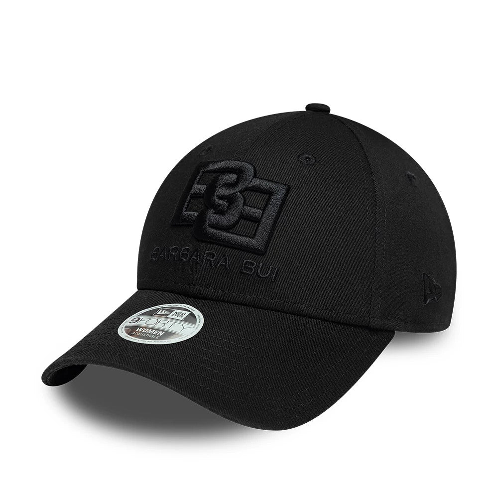 Womens New Era X Barbara Bui Core Black 9FORTY Adjustable Cap, three-quarter view showing the large black embroidered Barbara Bui logo on the front panel with a curved black visor and a 9FORTY size sticker.