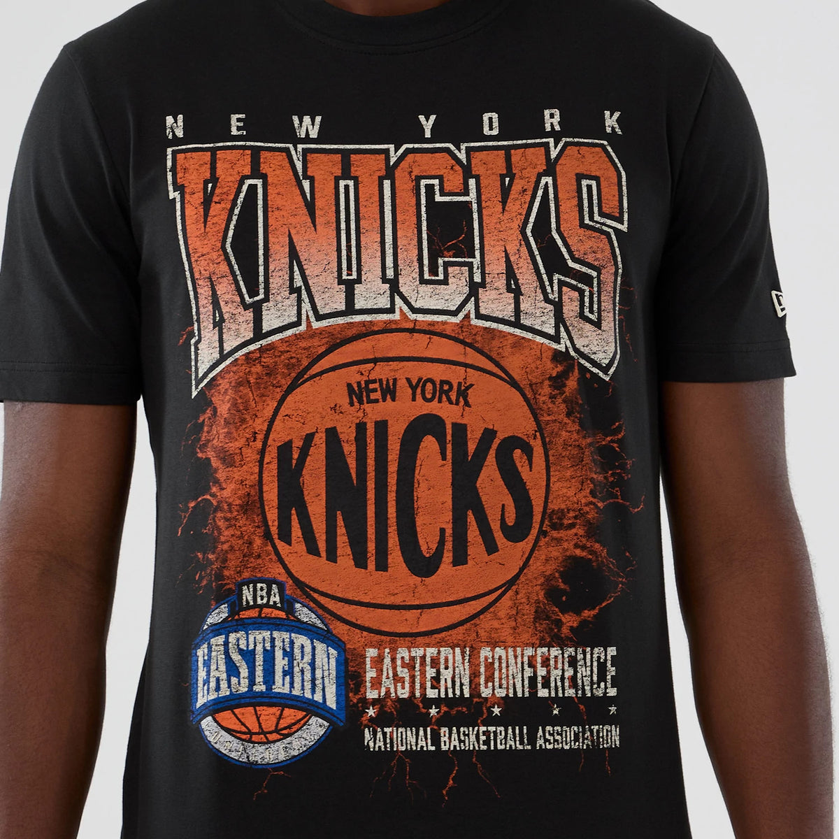 New Era New York Knicks NBA Hardwood Classic Black T-Shirt, front view showing an oversized distressed graphic with New York Knicks lettering over an orange basketball, additional NBA Eastern Conference text below.