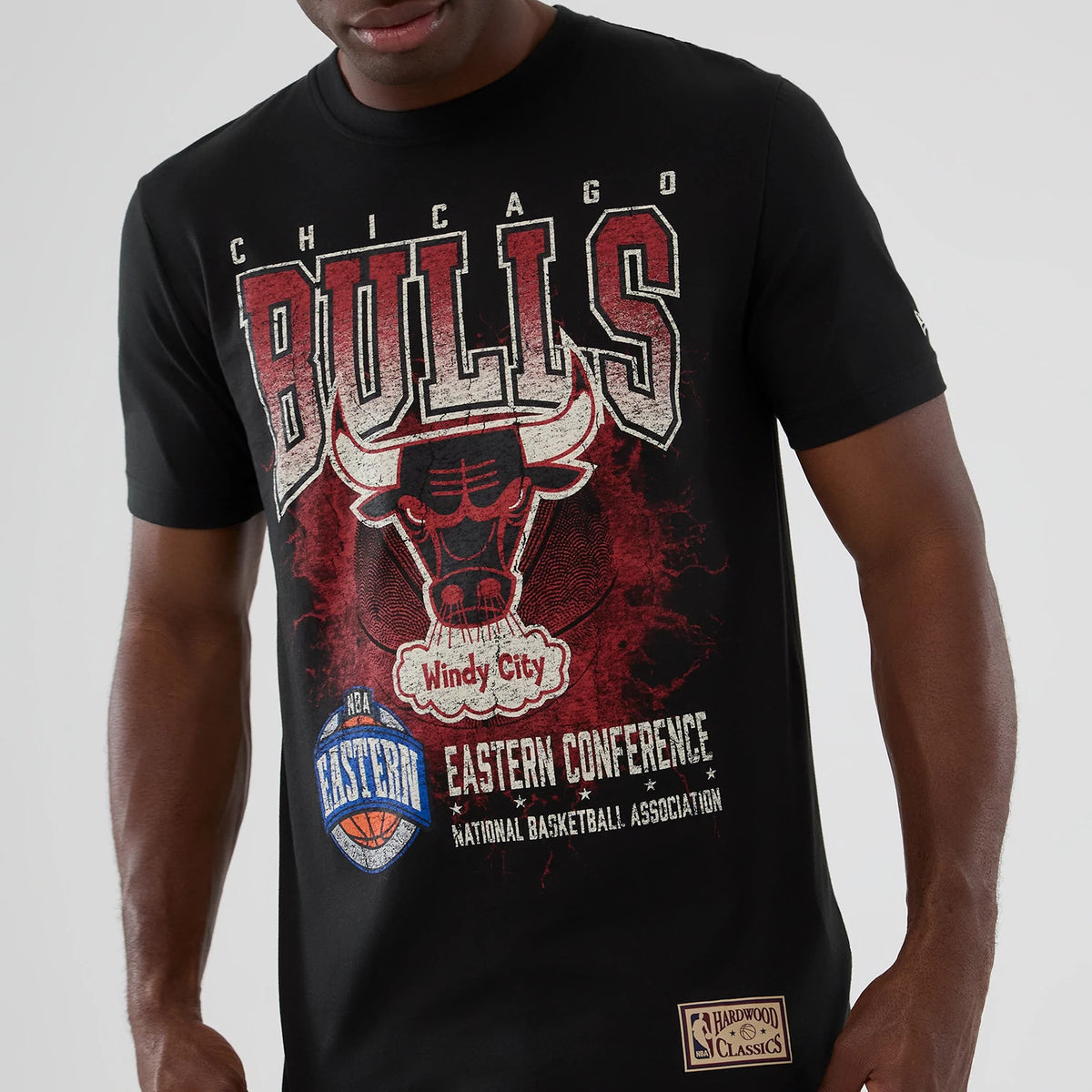 New Era Chicago Bulls NBA Hardwood Classic Black T-Shirt, front view showing a red and white Bulls graphic with Windy City text beneath, Eastern Conference and NBA logos, and a Hardwood Classics patch on the hem.