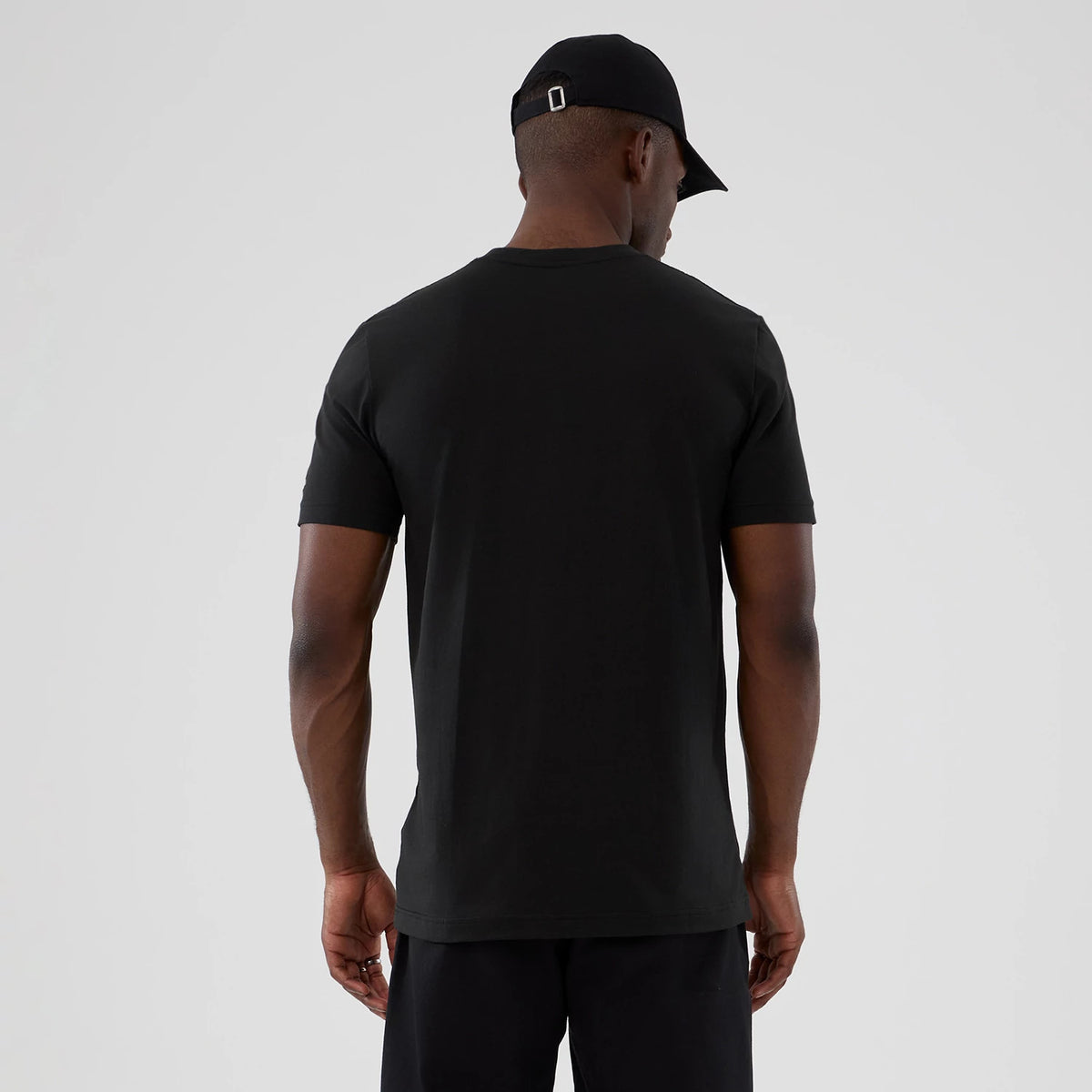 New Era Chicago Bulls NBA Hardwood Classic Black T-Shirt, back view on a model wearing a black cap, highlighting the plain black jersey tee with short sleeves and a simple crew neck design.