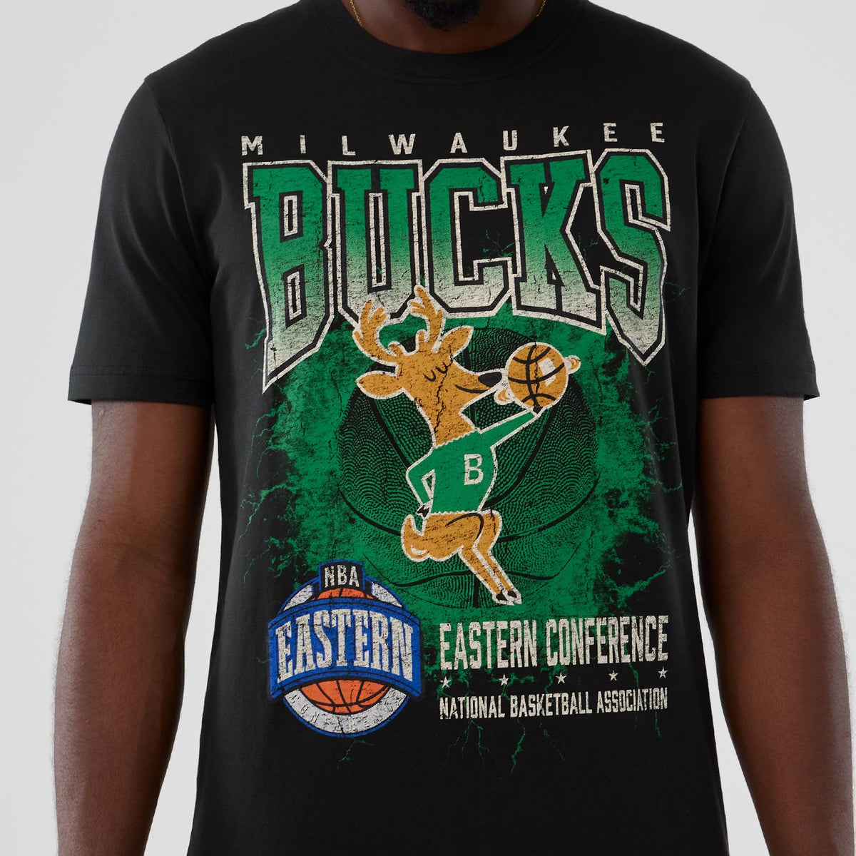 New Era Milwaukee Bucks NBA Hardwood Classic Black T-Shirt, front view showing BUCKS lettering above a graphic of a deer spinning a basketball, with NBA Eastern Conference logos printed below on a black background.