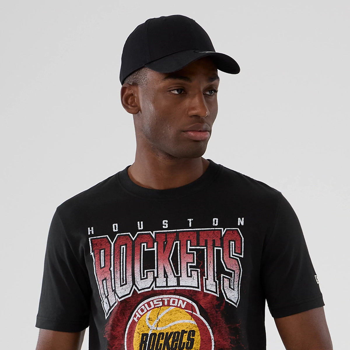 New Era Houston Rockets NBA Hardwood Classic Black T-Shirt, front view on-model showing the red and white Rockets lettering across the chest, a large graphic of a basketball with the team logo at the centre.