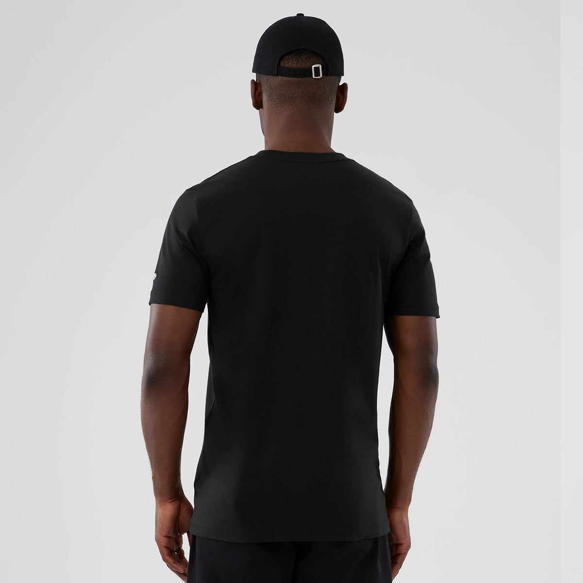 New Era Houston Rockets NBA Hardwood Classic Black T-Shirt, back view on a model showing the plain black design with the sleeves featuring an embroidered logo detail, paired with a black cap for a coordinated look.