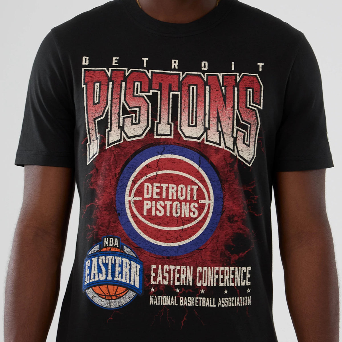 New Era Detroit Pistons NBA Hardwood Classic Black T-Shirt, front view with large distressed red and white Pistons graphic, circular Detroit Pistons logo in the centre and NBA Eastern Conference badge at the lower front.