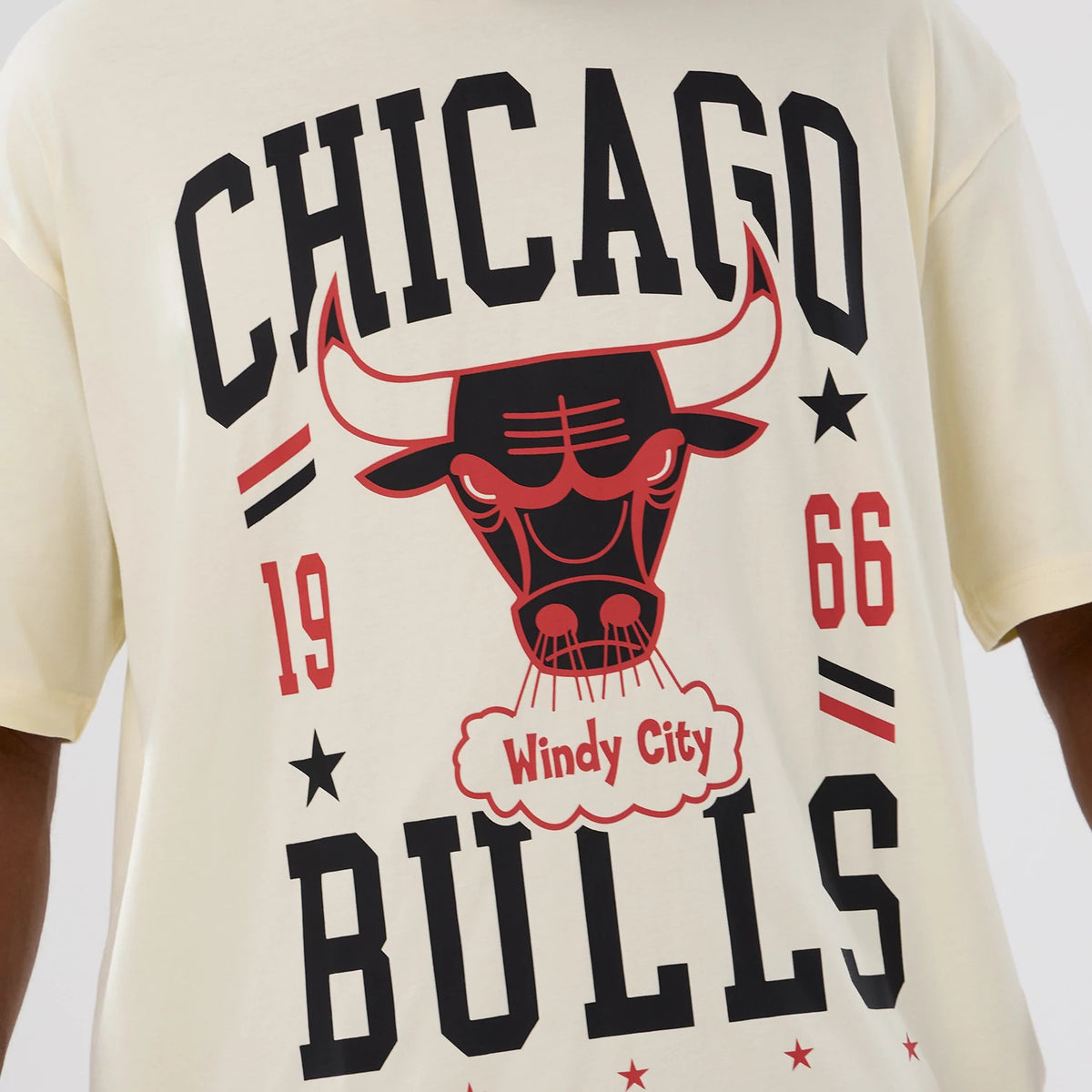 New Era Chicago Bulls NBA Hardwood Classic Cream T-Shirt, front view displaying a black CHICAGO lettering across the chest, a red bull graphic with Windy City text in the centre, flanked by 1966 numbers and stars.