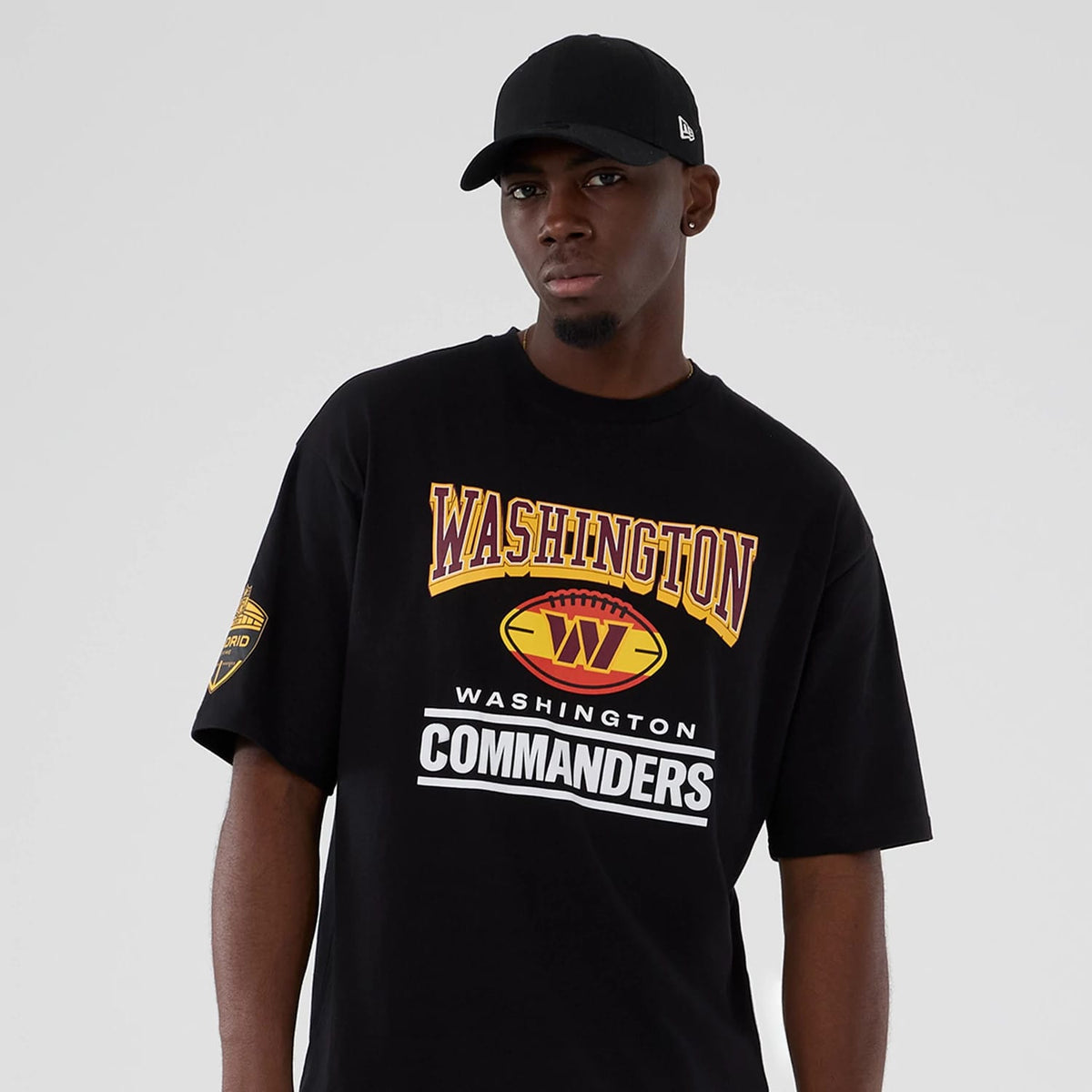 The Male model is wearing Washington Commanders Script NFL International Series Games 2025 Black Oversized T-Shirt 7