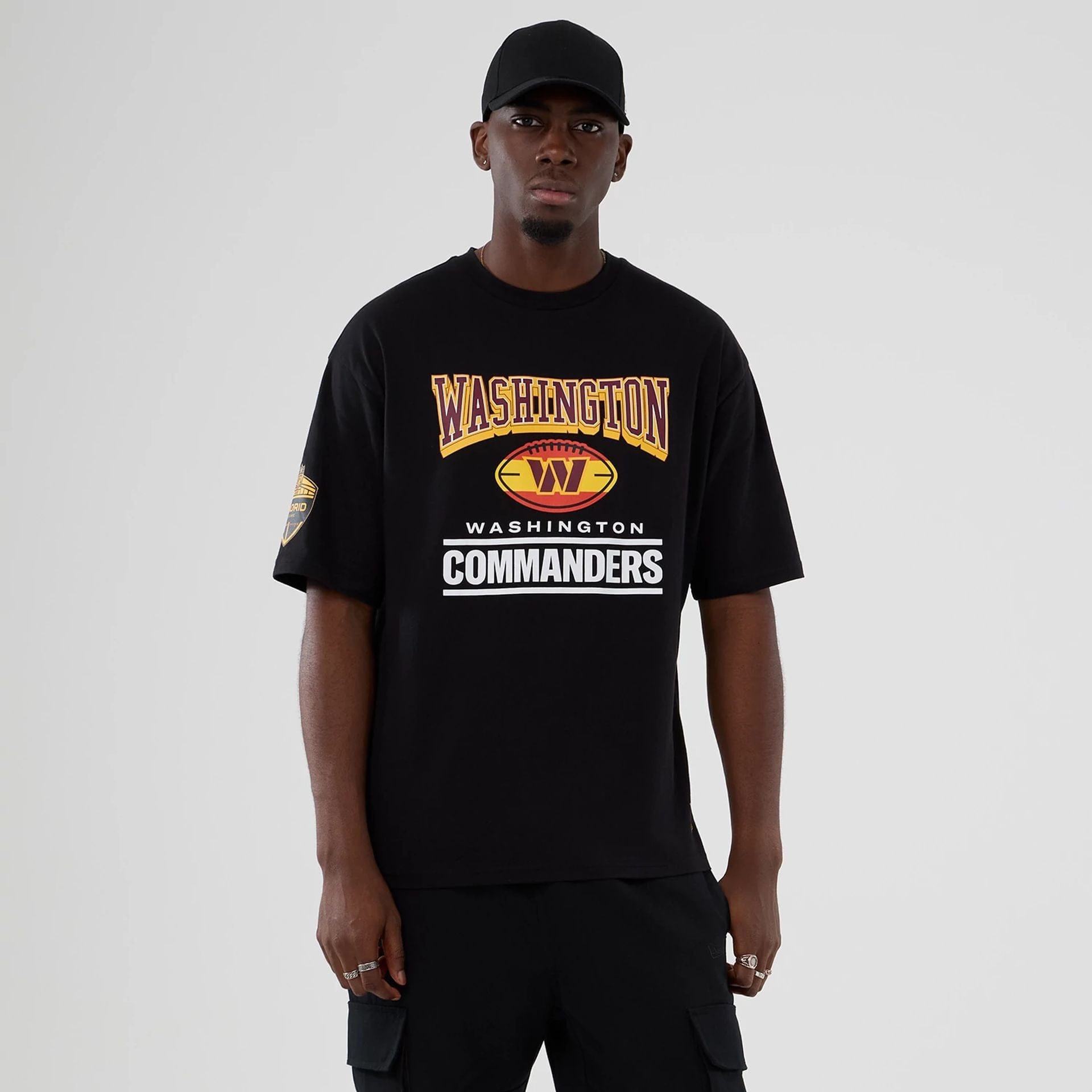 The Male model is wearing Washington Commanders NFL International Series Games 2025 Black Oversized T-Shirt 1