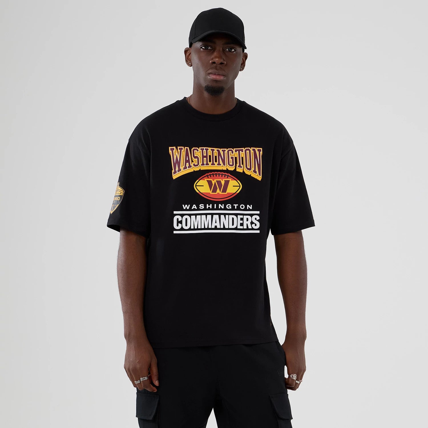 The Male model is wearing Washington Commanders Script NFL International Series Games 2025 Black Oversized T-Shirt 1