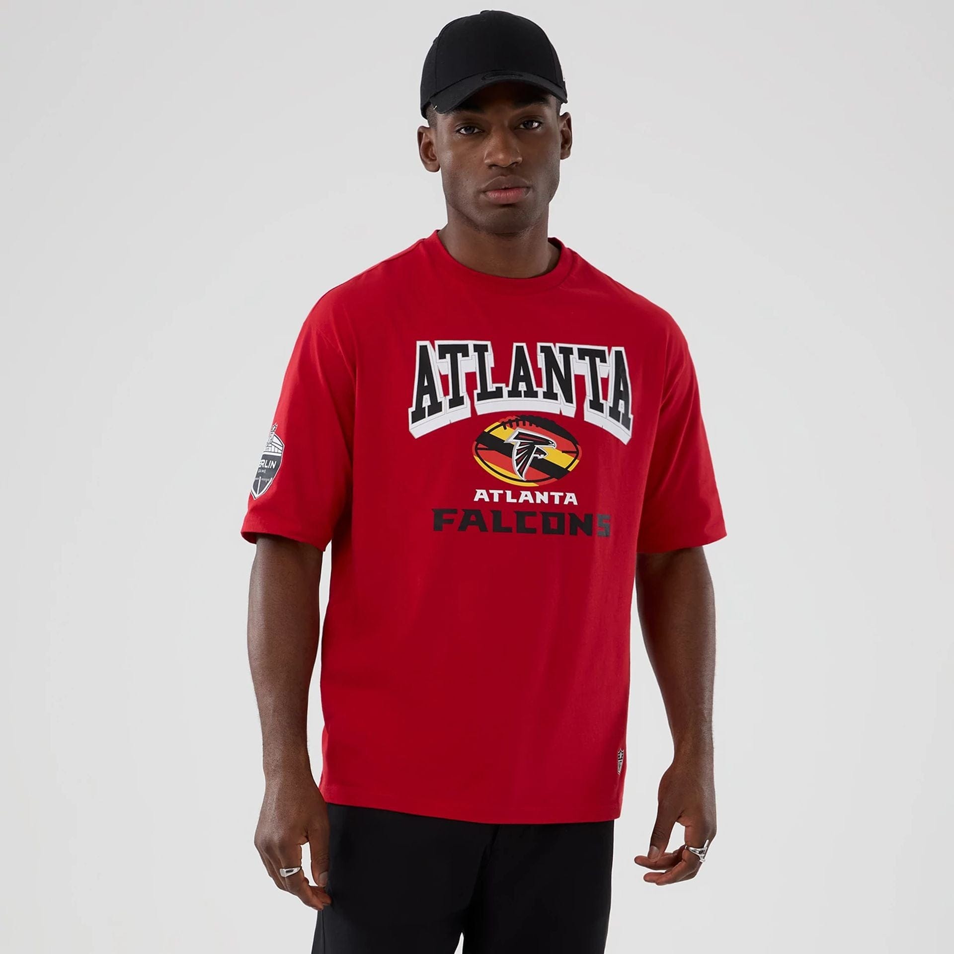 The Male model is wearing Atlanta Falcons NFL International Series Games 2025 Red Oversized T-Shirt 1