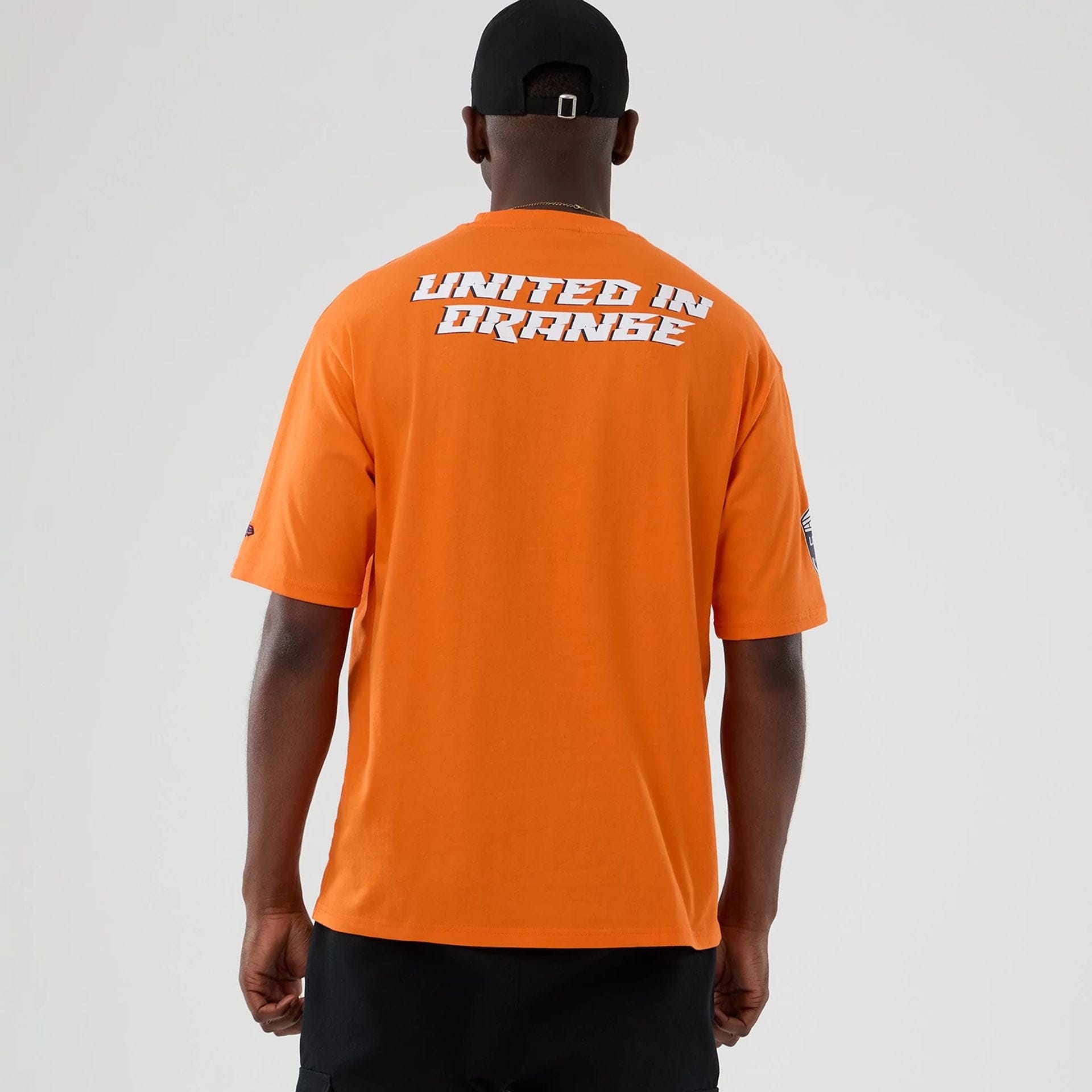 The Male model is wearing Denver Broncos NFL International Series Games 2025 Orange Oversized T-Shirt 2