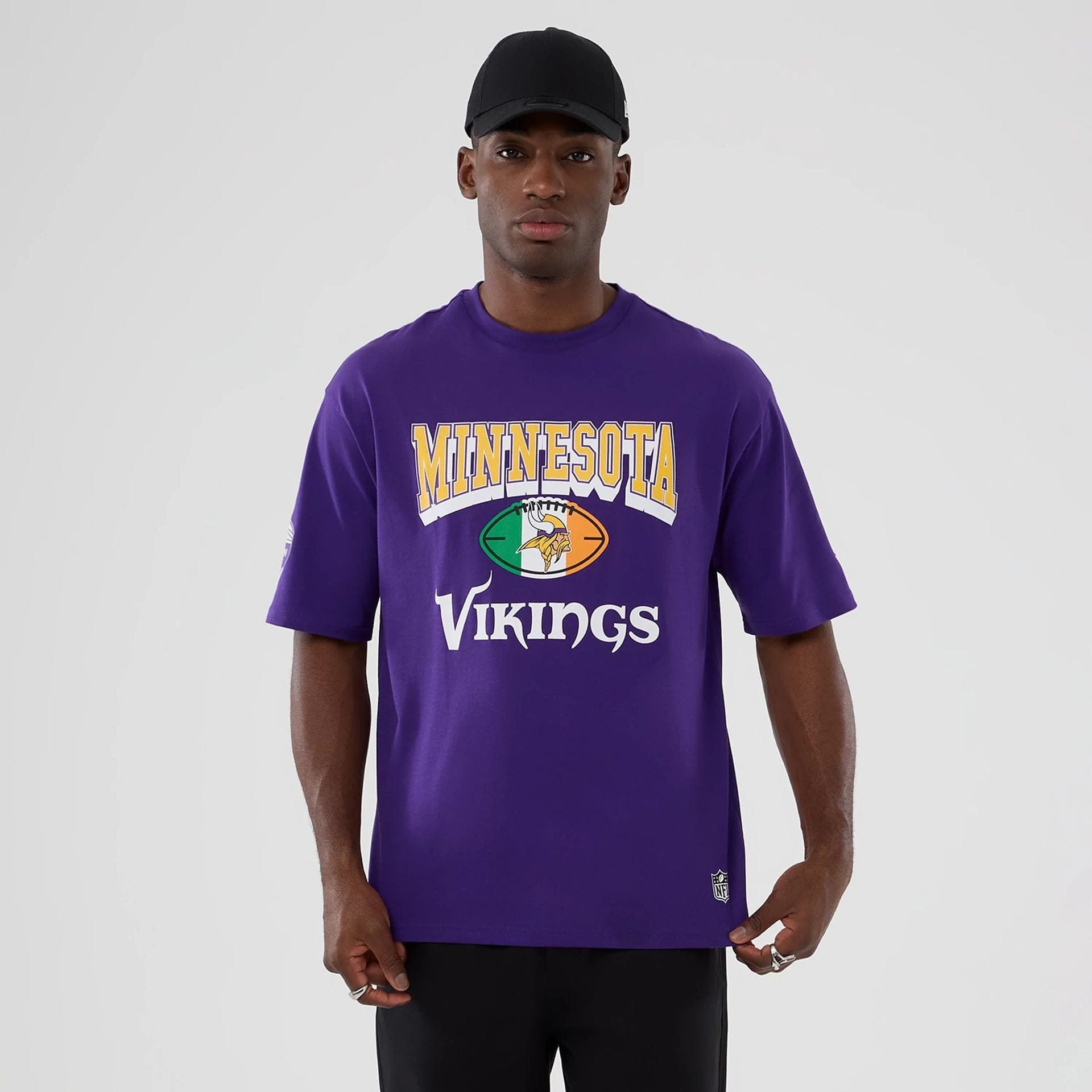 The Male model is wearing Minnesota Vikings NFL International Series Games 2025 Purple Oversized T-Shirt 1