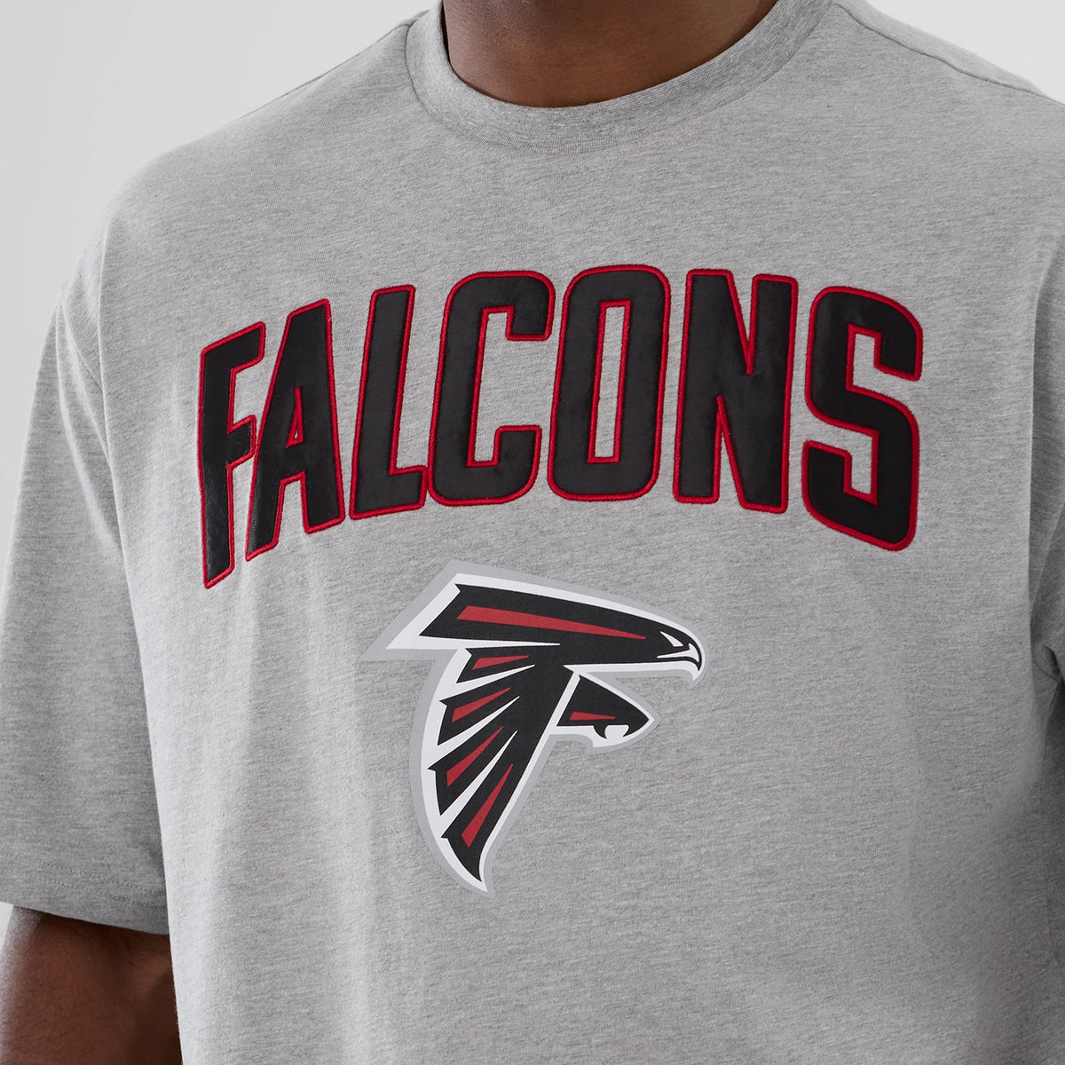 New Era Atlanta Falcons NFL International Series Games 2025 Grey Premium T-Shirt, front view displaying Falcons lettering in black and red across the chest and the team's logo printed below it on a grey background.