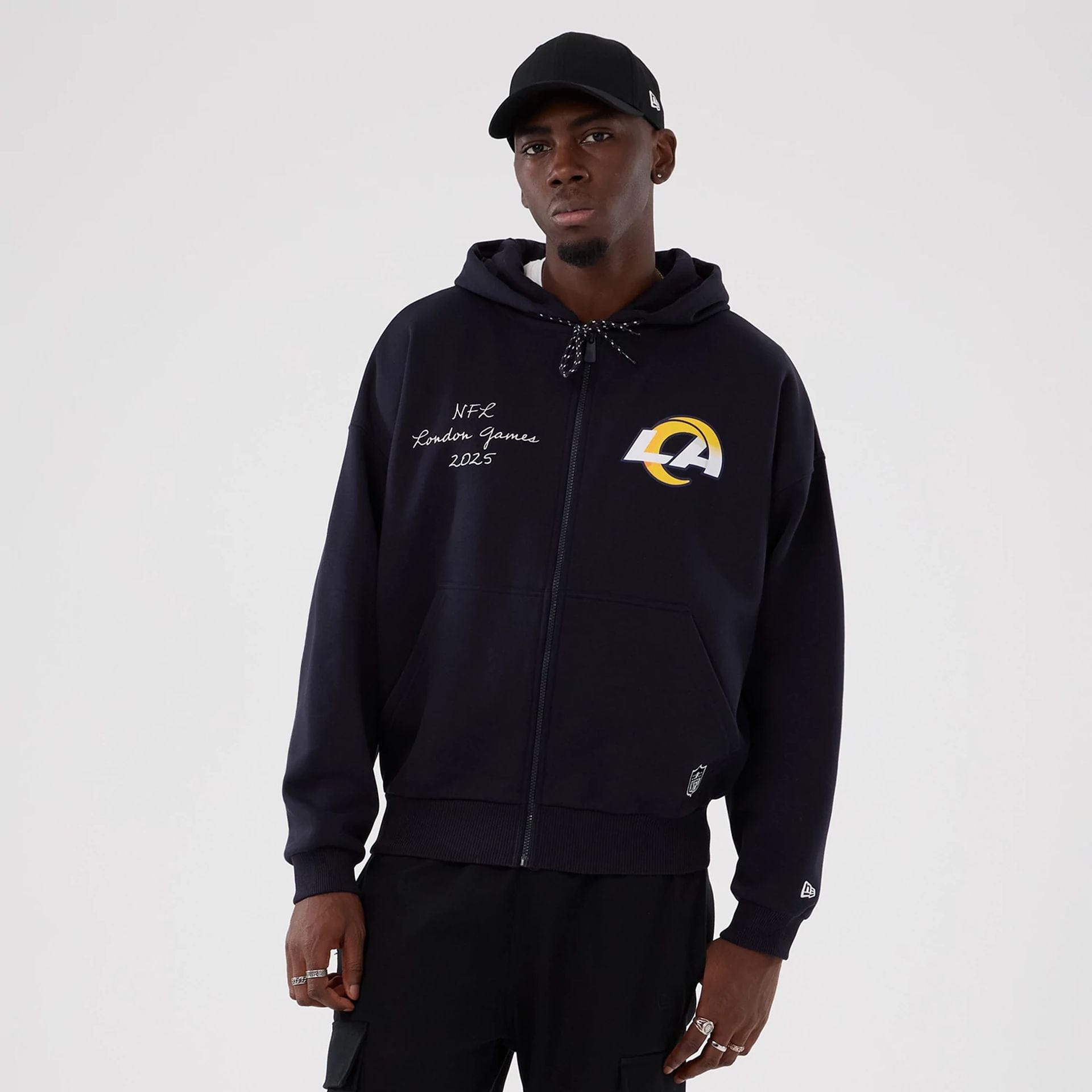 The Male model is wearing LA Rams NFL International Series Games 2025 Navy Premium Pullover Hoodie 1